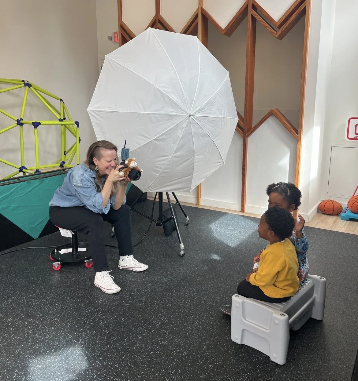 School portrait photographer interacting with preschool child during photo day in San Francisco