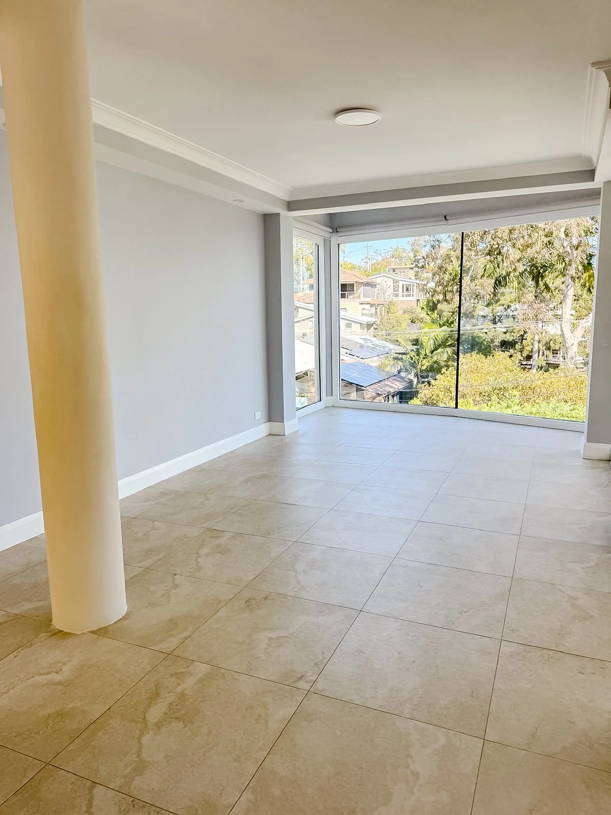 Before styling: empty living room with full-height windows and water views, Clontarf