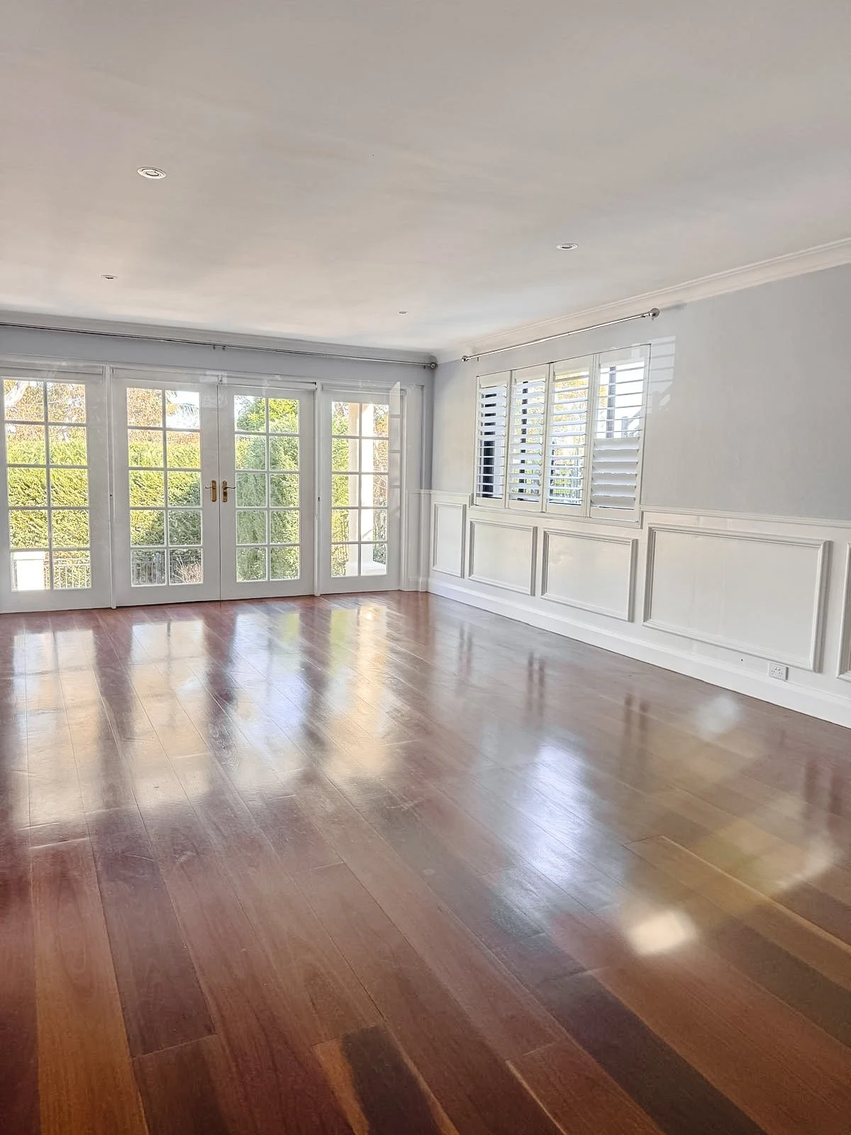 Before styling: empty bedroom with polished timber floors and panelled walls, Clontarf