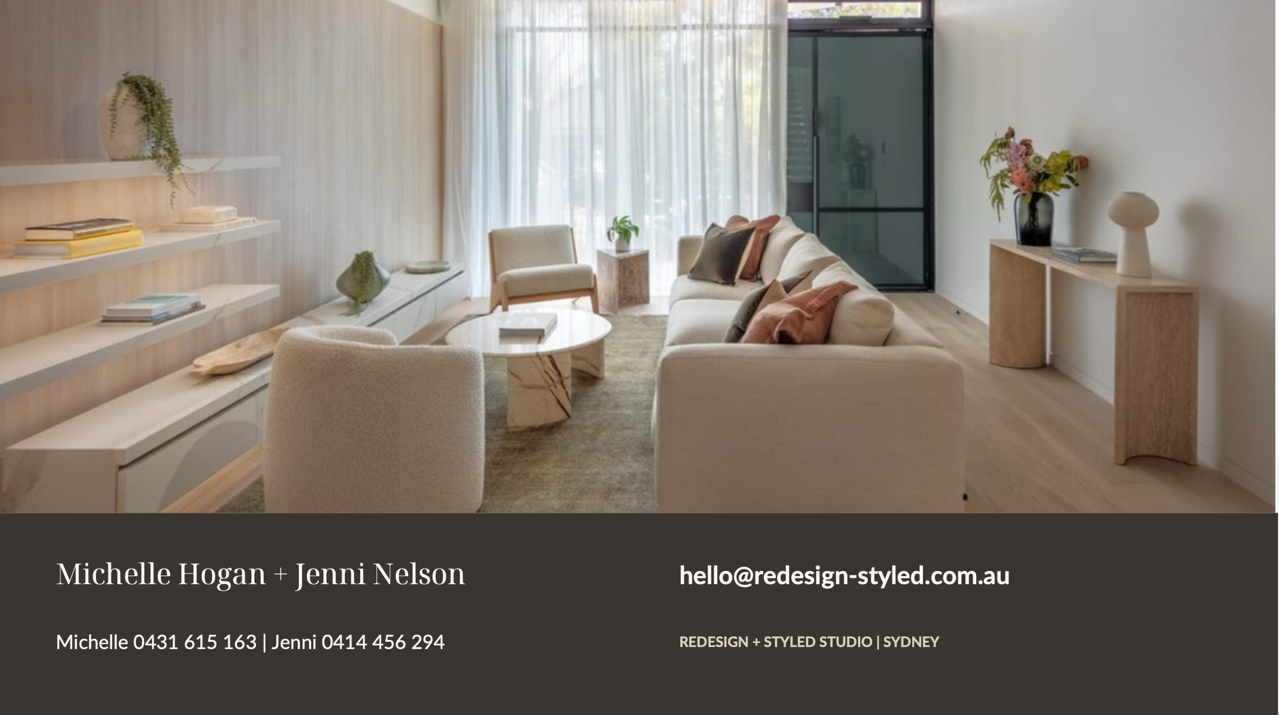 Modern living room with white sofa, armchair, round coffee table, wooden side tables, shelves with books and plants, large window with sheer curtains, hardwood floors, and decorative vases and flowers.