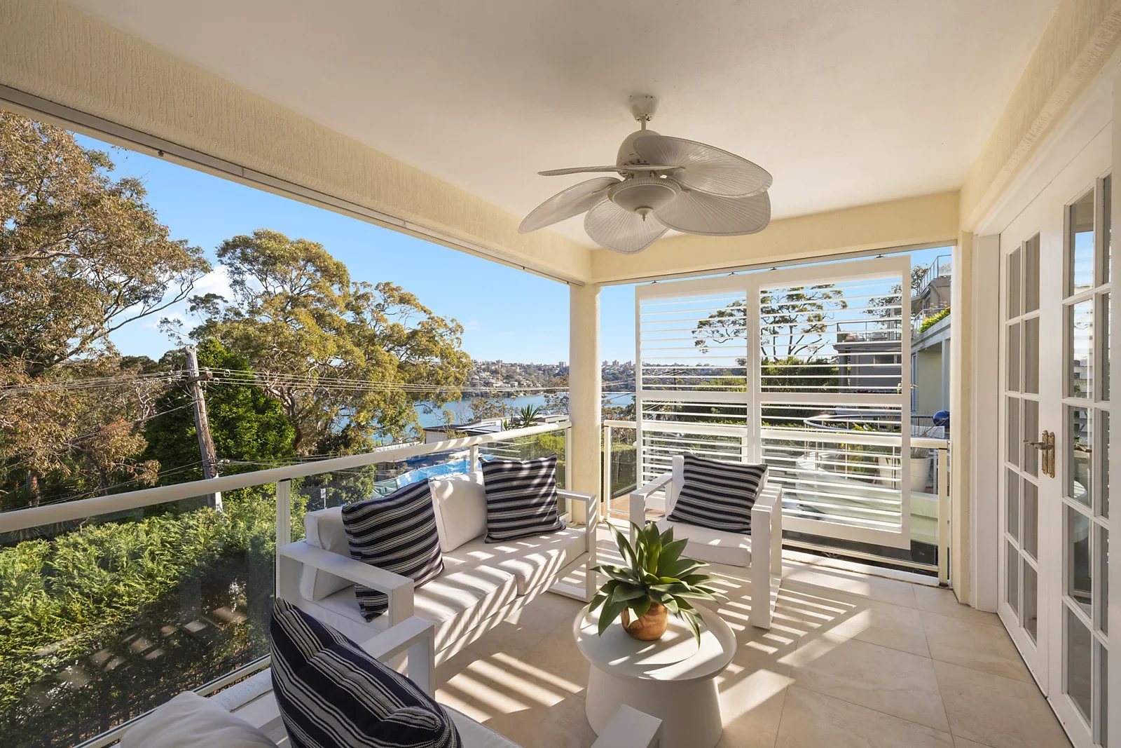 Balcony styled for sale with striped outdoor seating and water views, Clontarf