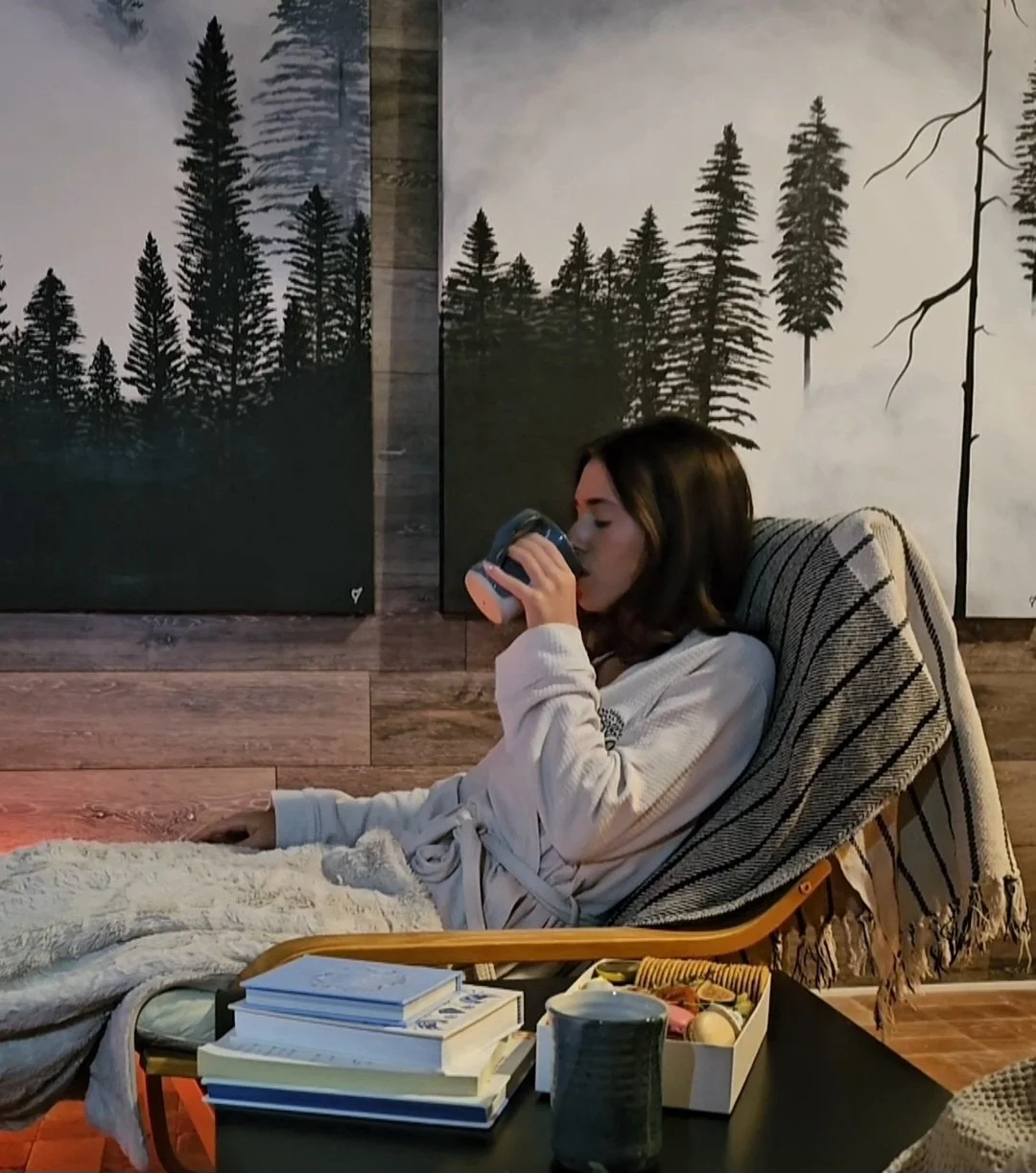 Woman in robe relaxing in chair drinking tea in the Salt Haven