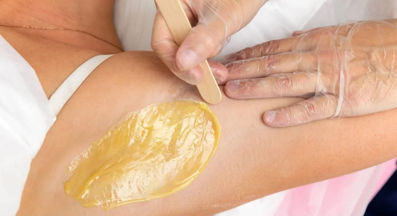 Woman having her underarm waxed