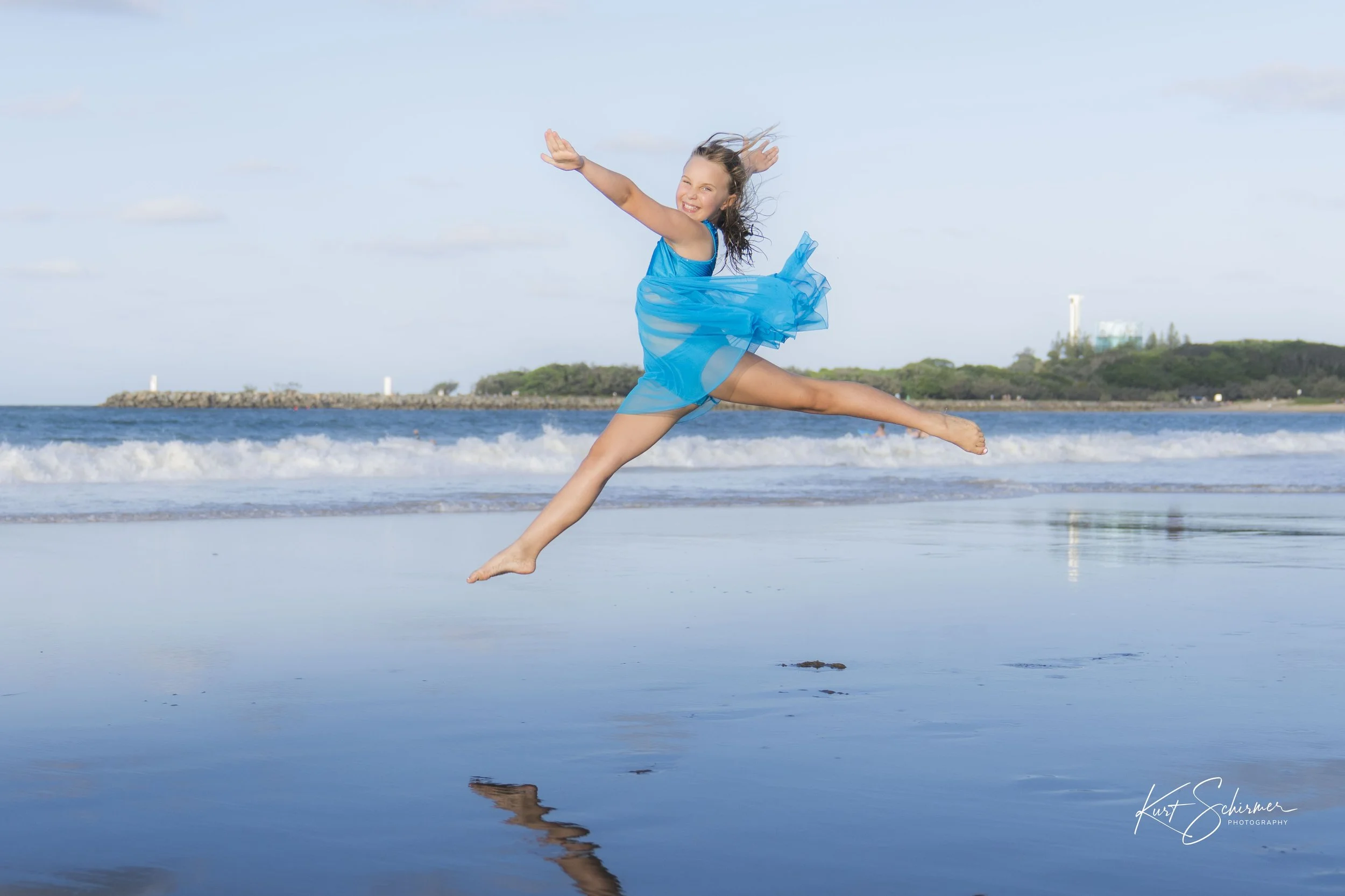 Underwater shot of a person wrapped in white fabric, gracefully posed in darkness.