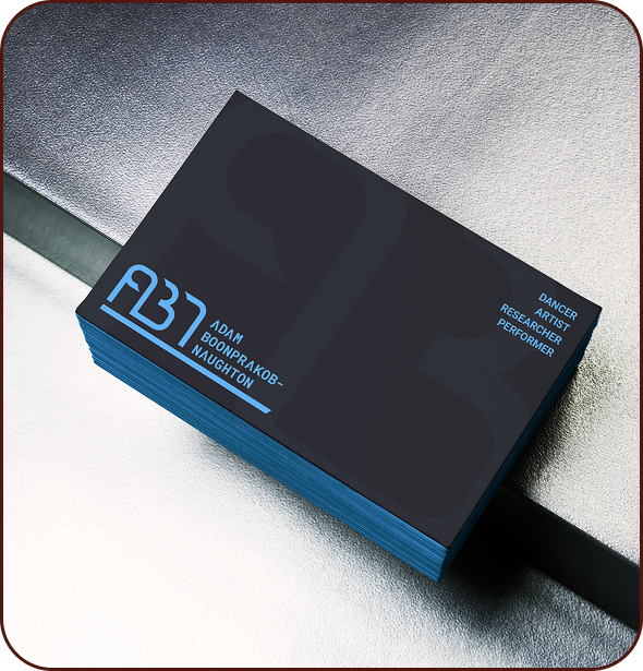 Stack of business cards with dark background and blue text, featuring a logo and the name Adam BookPrakov Naughton, along with the words Dancer, Artist, Researcher, Performer.