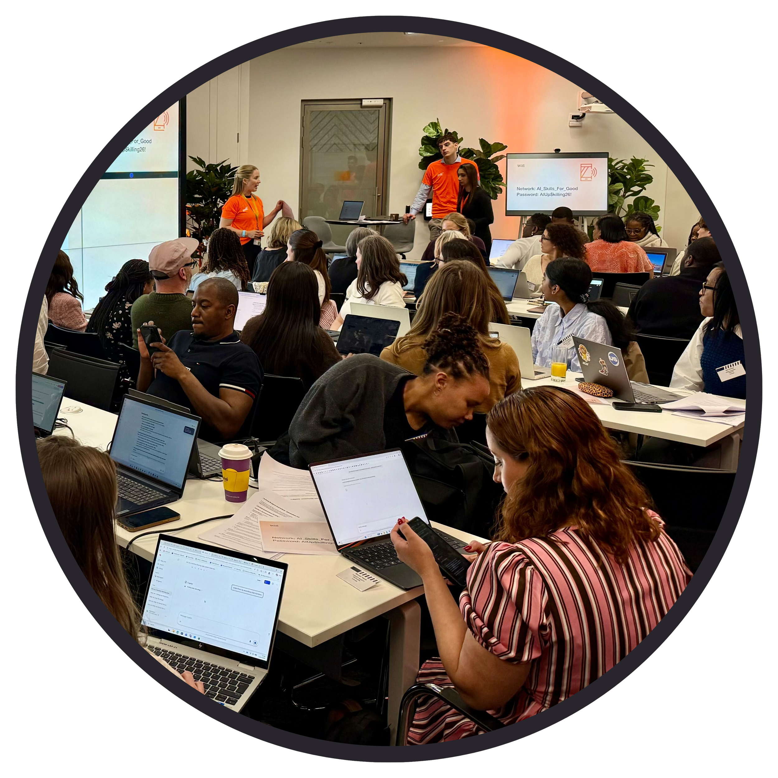 Circular image of employees working busily on laptops in the office