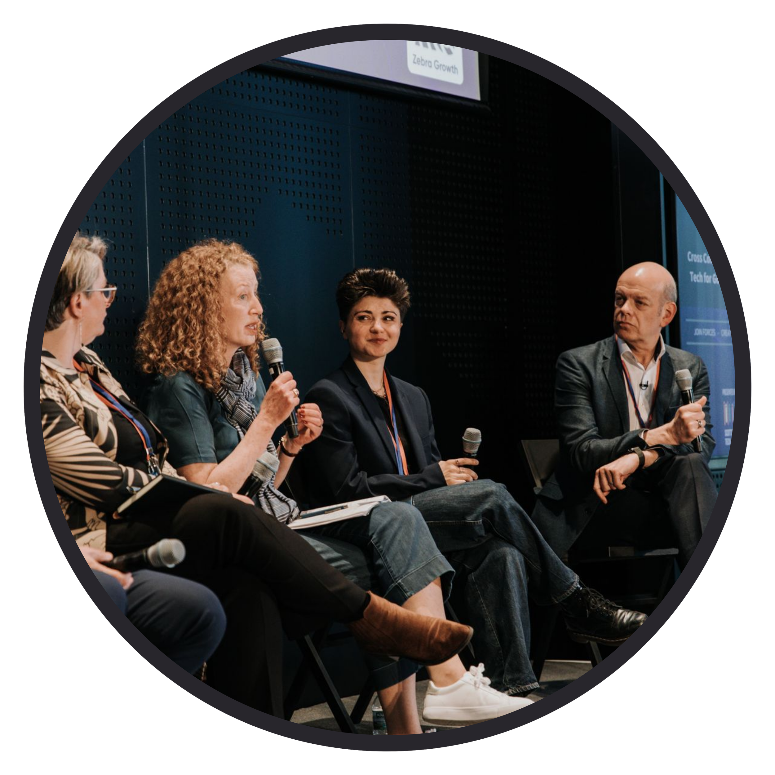 Photograph of a panel discussion, four people sitting on chairs with mics.