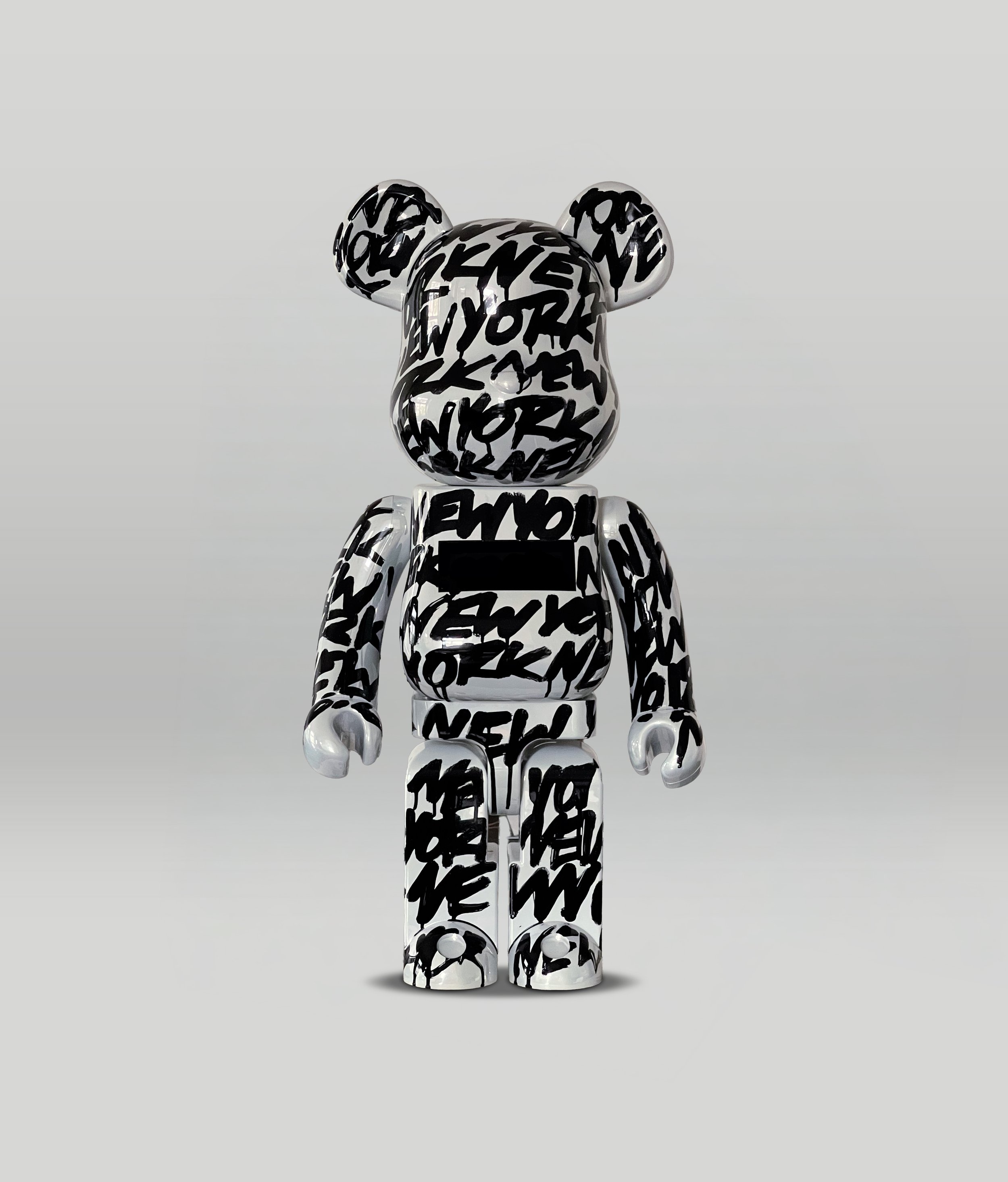 Kunstfigur eines Hundes mit einem schwarzen und weißen Muster, das aus wiederholten Wörtern wie 'NEW', 'YORK' und 'LOVE' besteht, auf einem weißen Hintergrund.