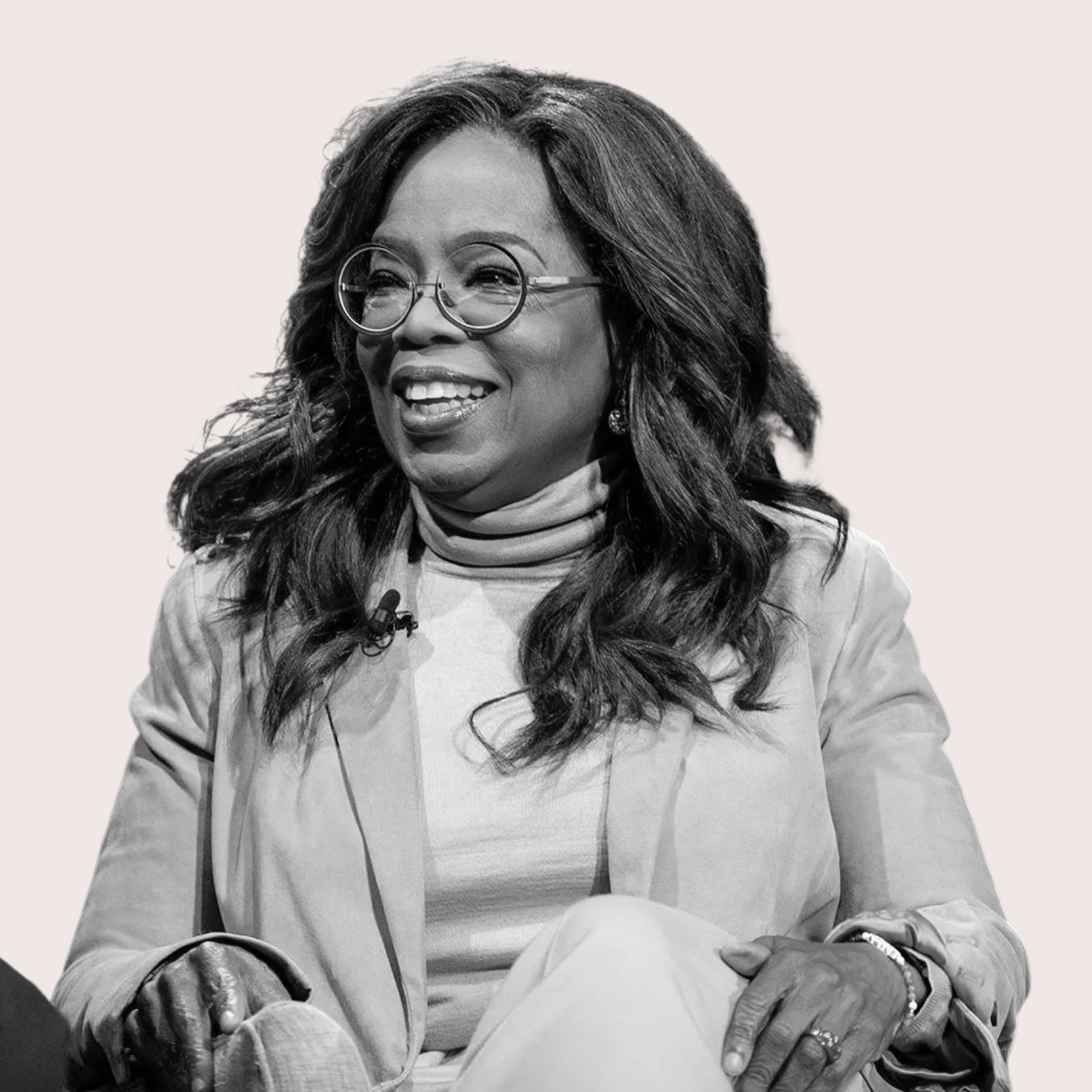 A woman with long, wavy hair and glasses, smiling and talking during a interview or conversation. Best confidence self esteem training program for women