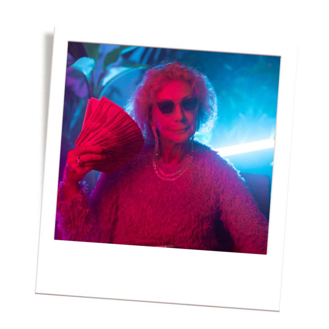 Older woman with curly hair wearing sunglasses and a furry sweater, holding pink fan of money, illuminated by blue and pink neon lights.