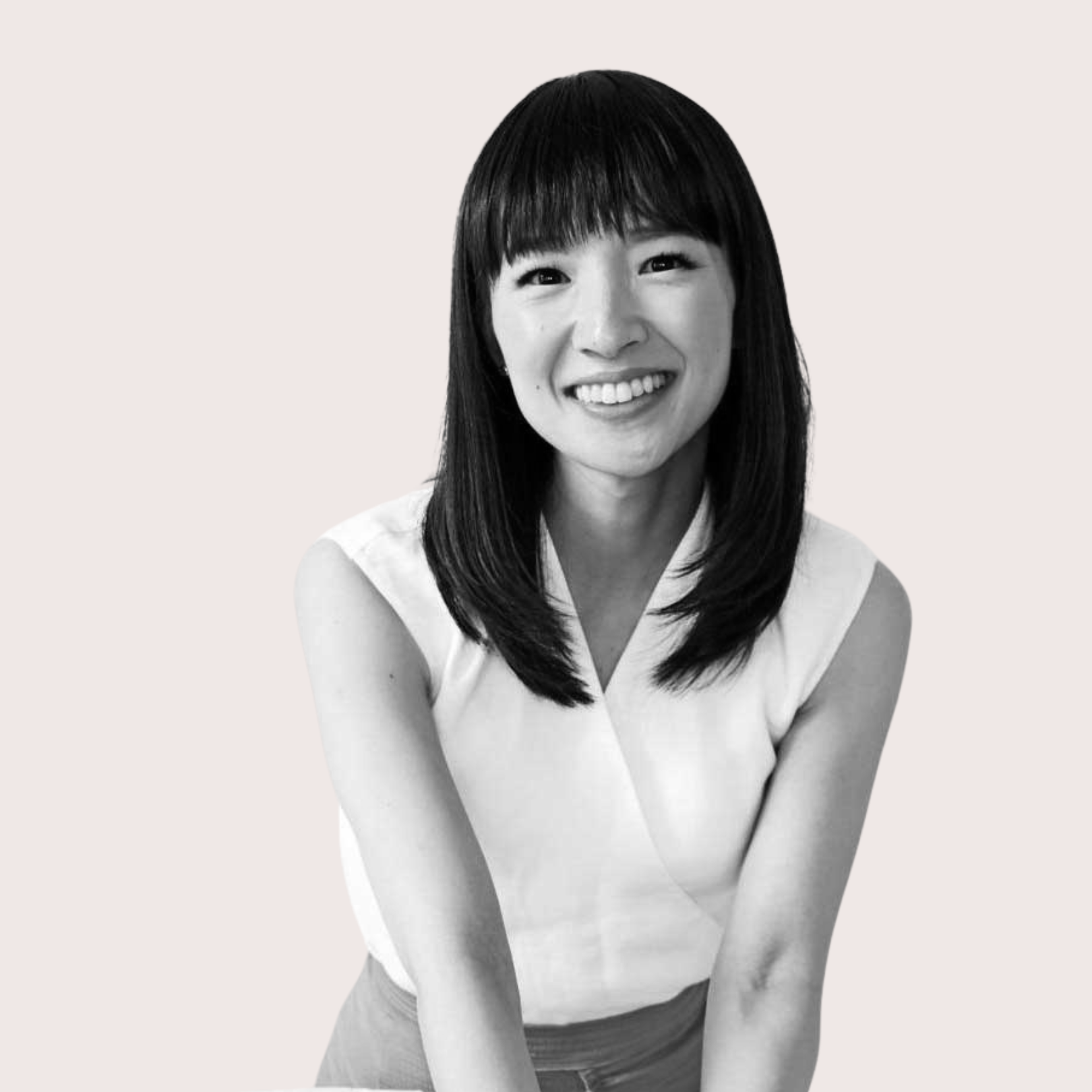 Black and white portrait of a smiling woman with straight dark hair and bangs, wearing a sleeveless top. Confidence development and self-esteem courses