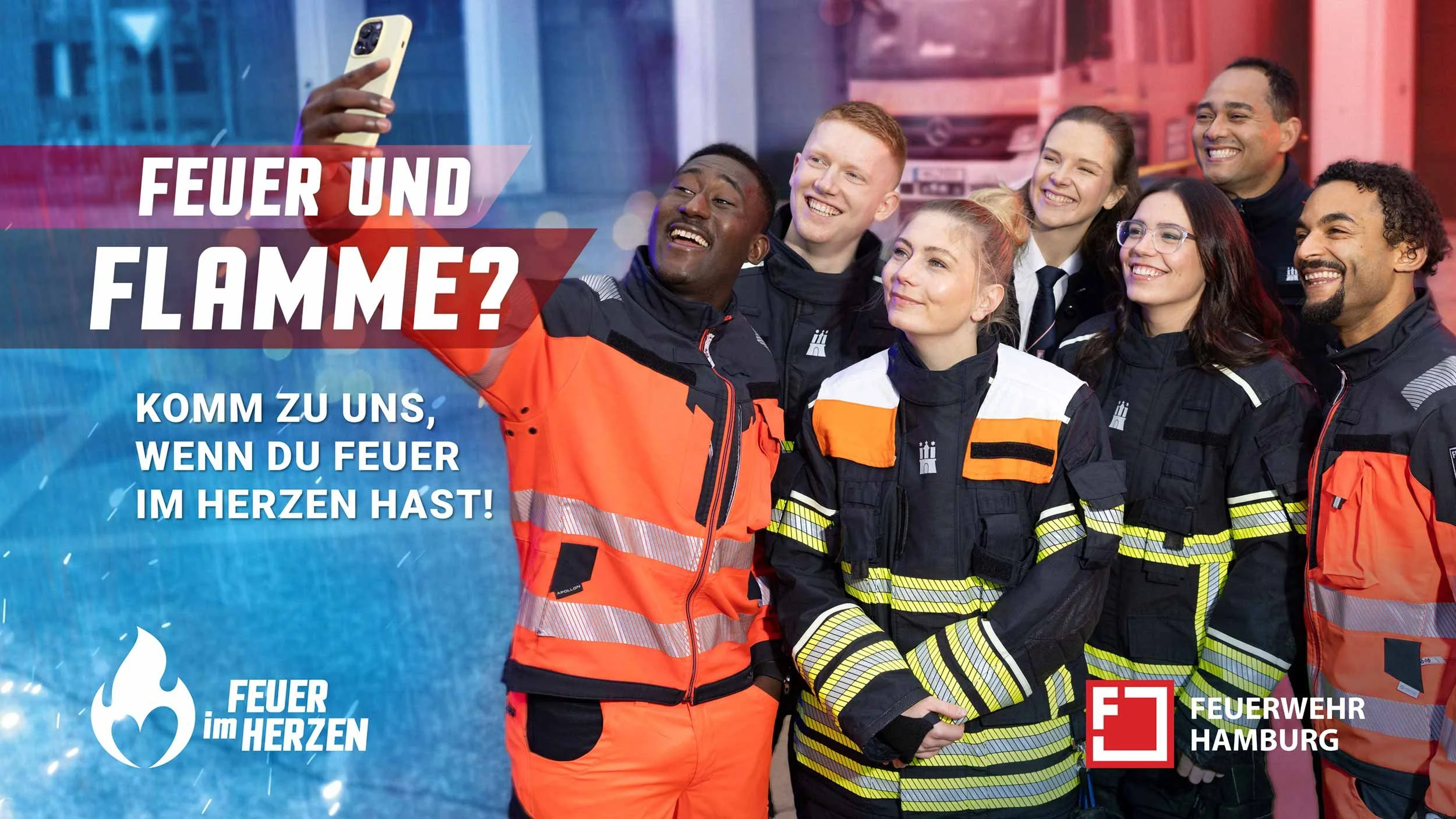 Gruppe von Nachwuchskräften der Feuerwehr Hamburg vor einem Feuerwehrfahrzeug auf dem Gelände einer Feuerwache.