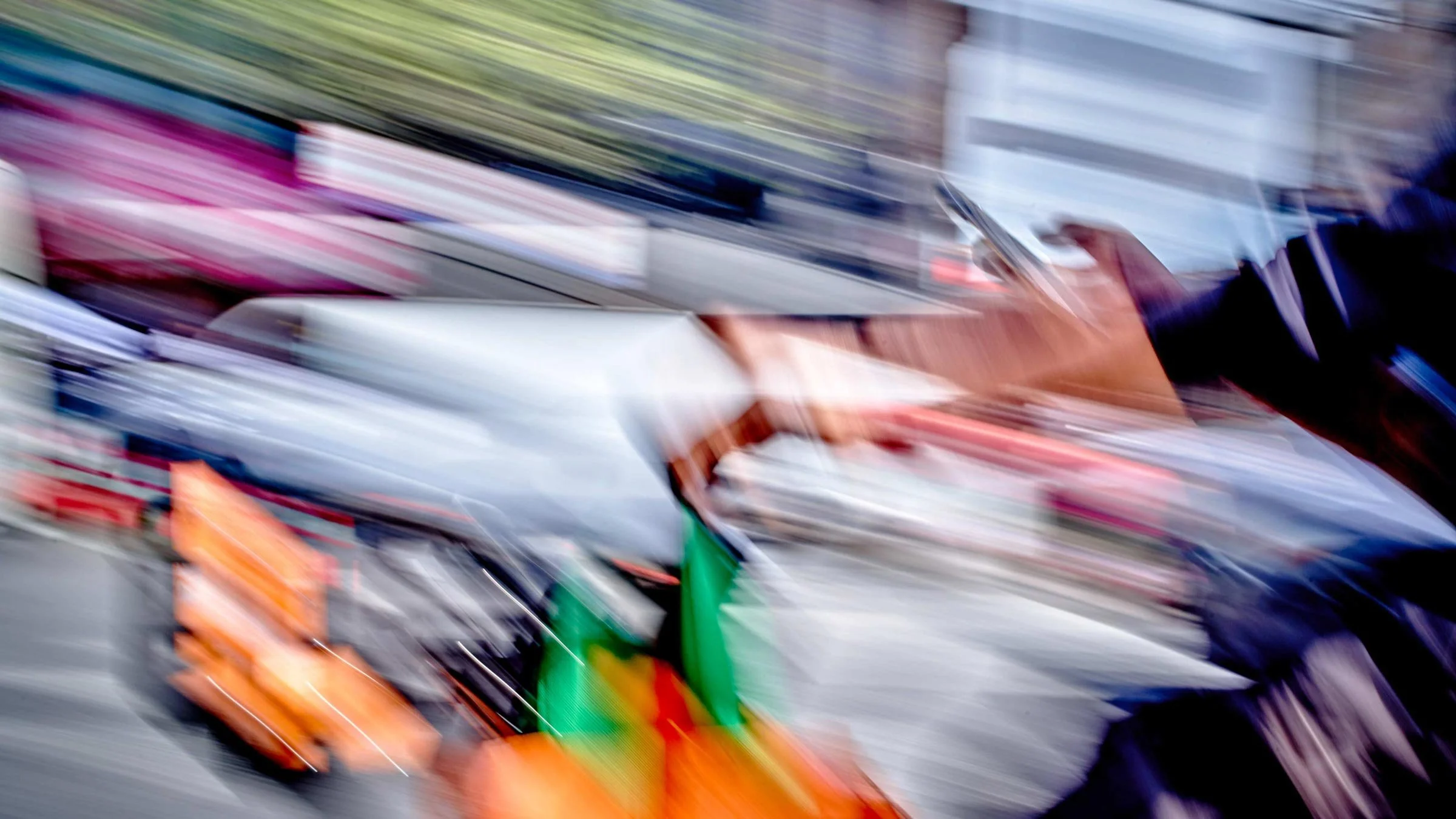 Ein Fahrradkurier fährt durch Manhattan, während er auf sein Handy schaut. Das Bild ist bunt und verschwommen.