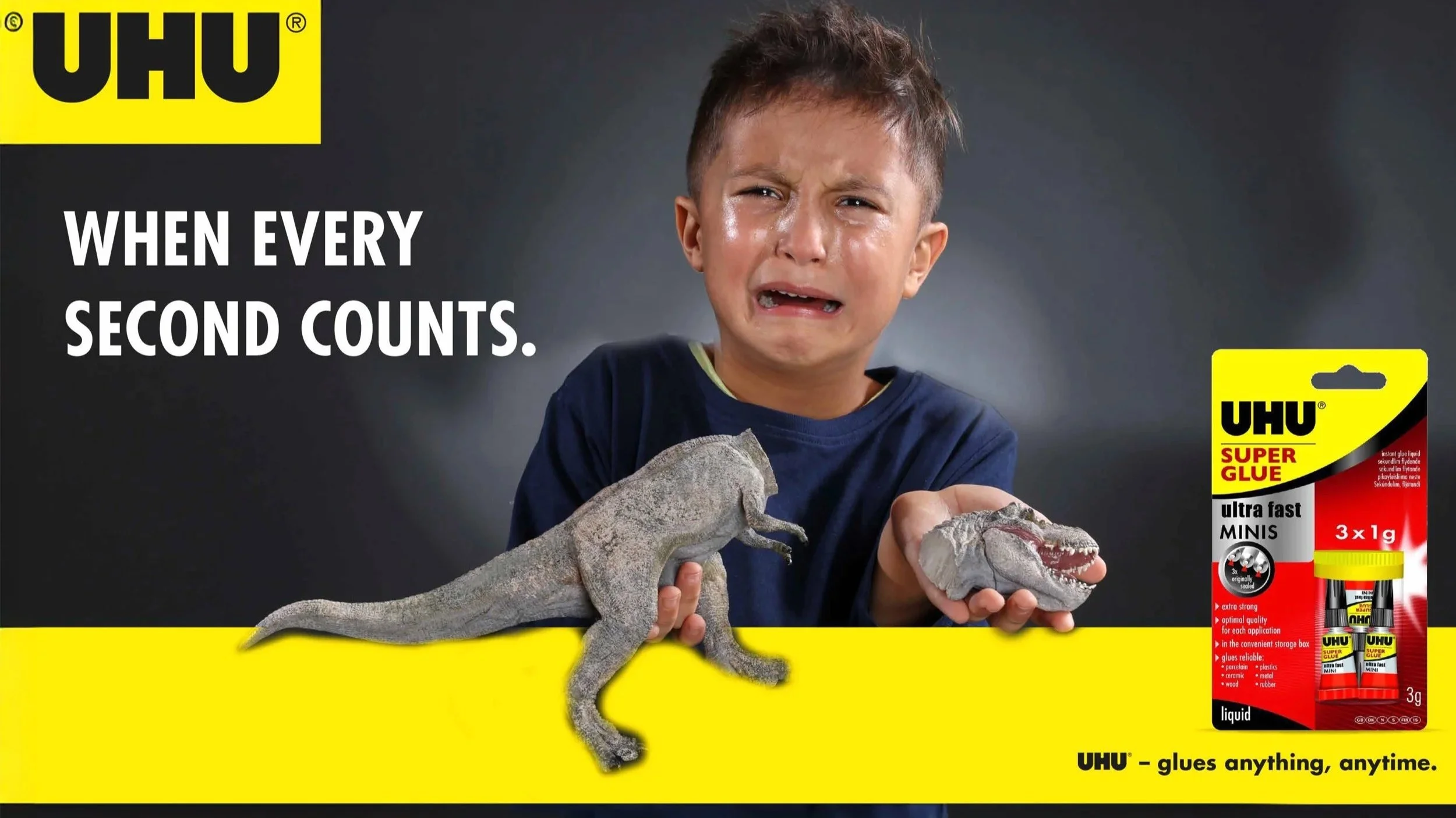 Kampagnenfoto von UHU Superkleber: Emotionales Werbeplakat mit Kind und zerbrochenem Spielzeug Dinosaurier.