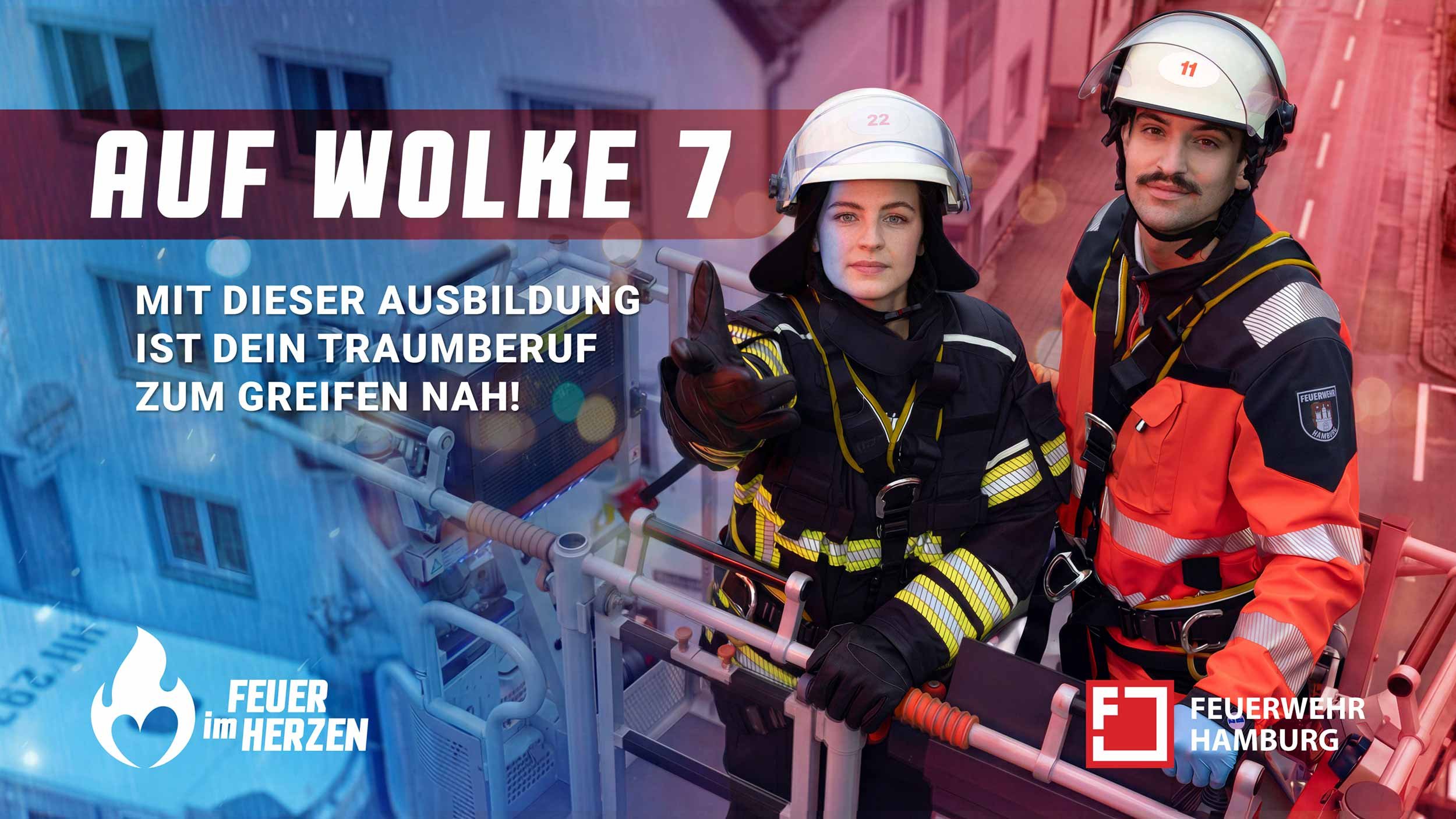 Feuerwehrfrau und Feuerwehrmann auf einer Drehleiter der Feuerwehr Hamburg über einem Betriebsgelände.