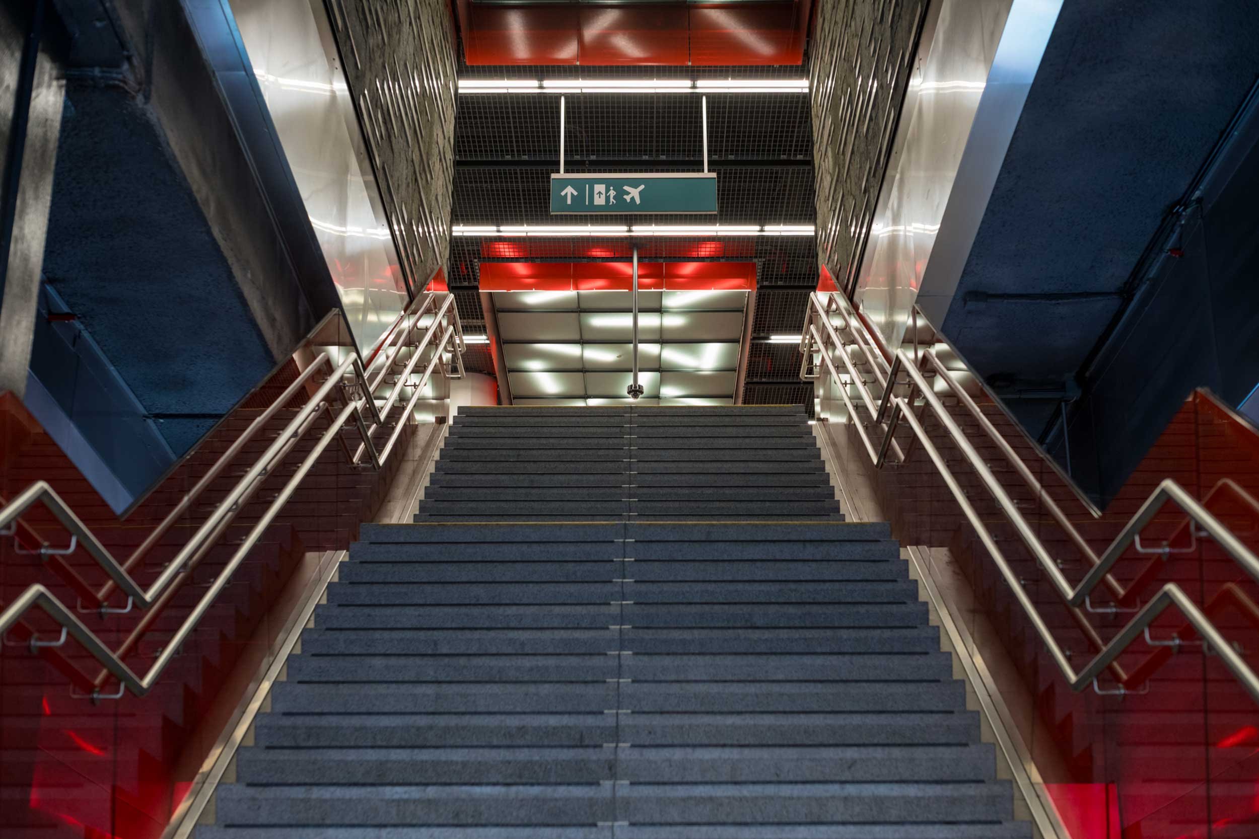 Breite treppe mit handlaeufen fuehrt zu einem bahnsteig mit leitschild in bruessel