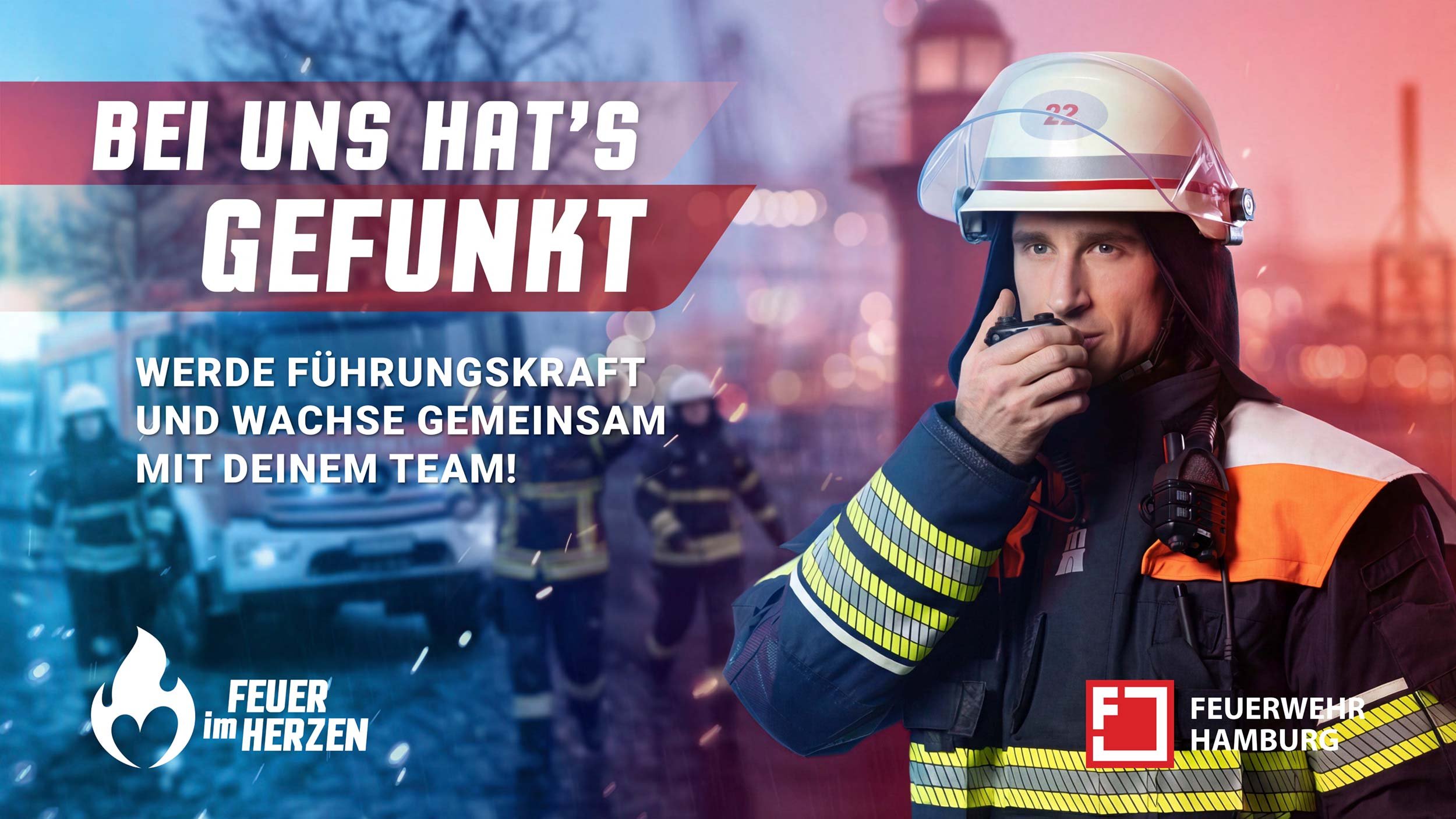Feuerwehrmann der Feuerwehr Hamburg mit Funkgerät und Einsatzkleidung vor Einsatzfahrzeugen.