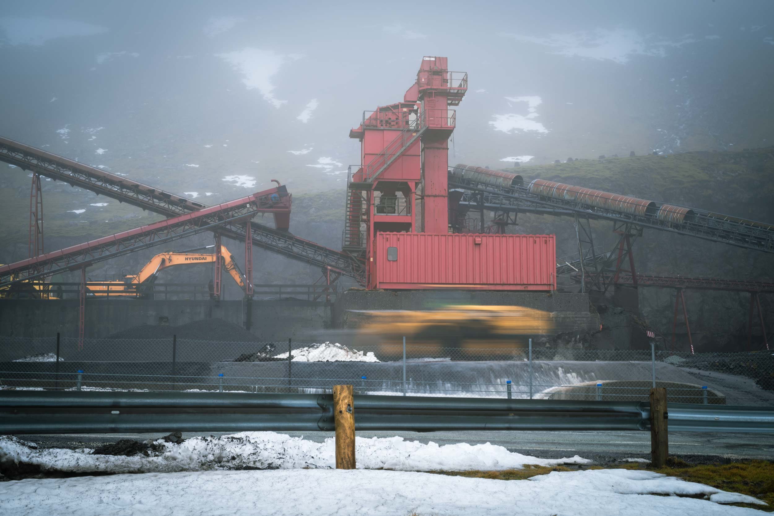 Industrieanlage mit rotem turm und foerderbaendern in nebliger landschaft, faeroer