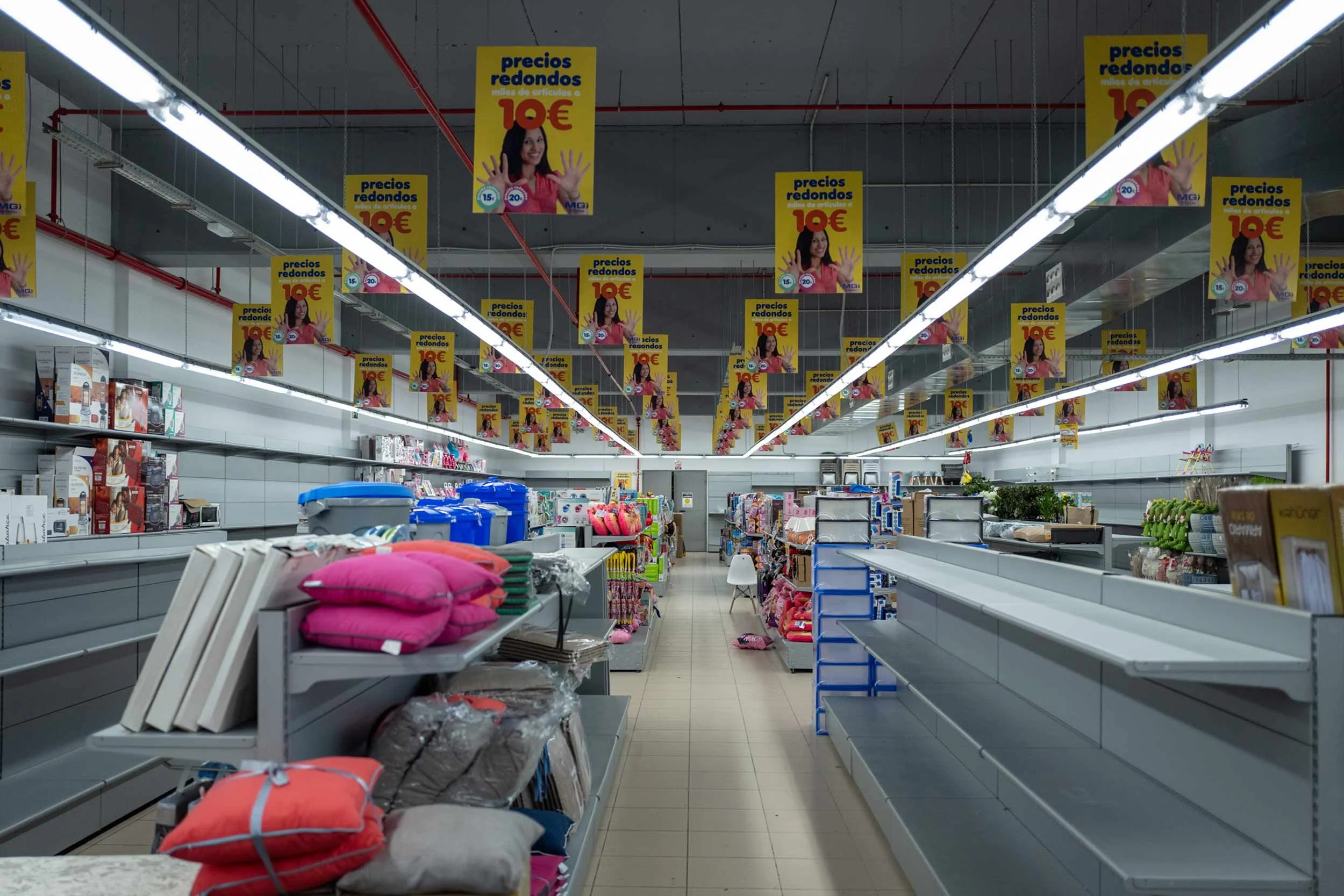 Innenraum eines geschaefts mit leeren regalen und gelben preisschildern an der decke, gran canaria