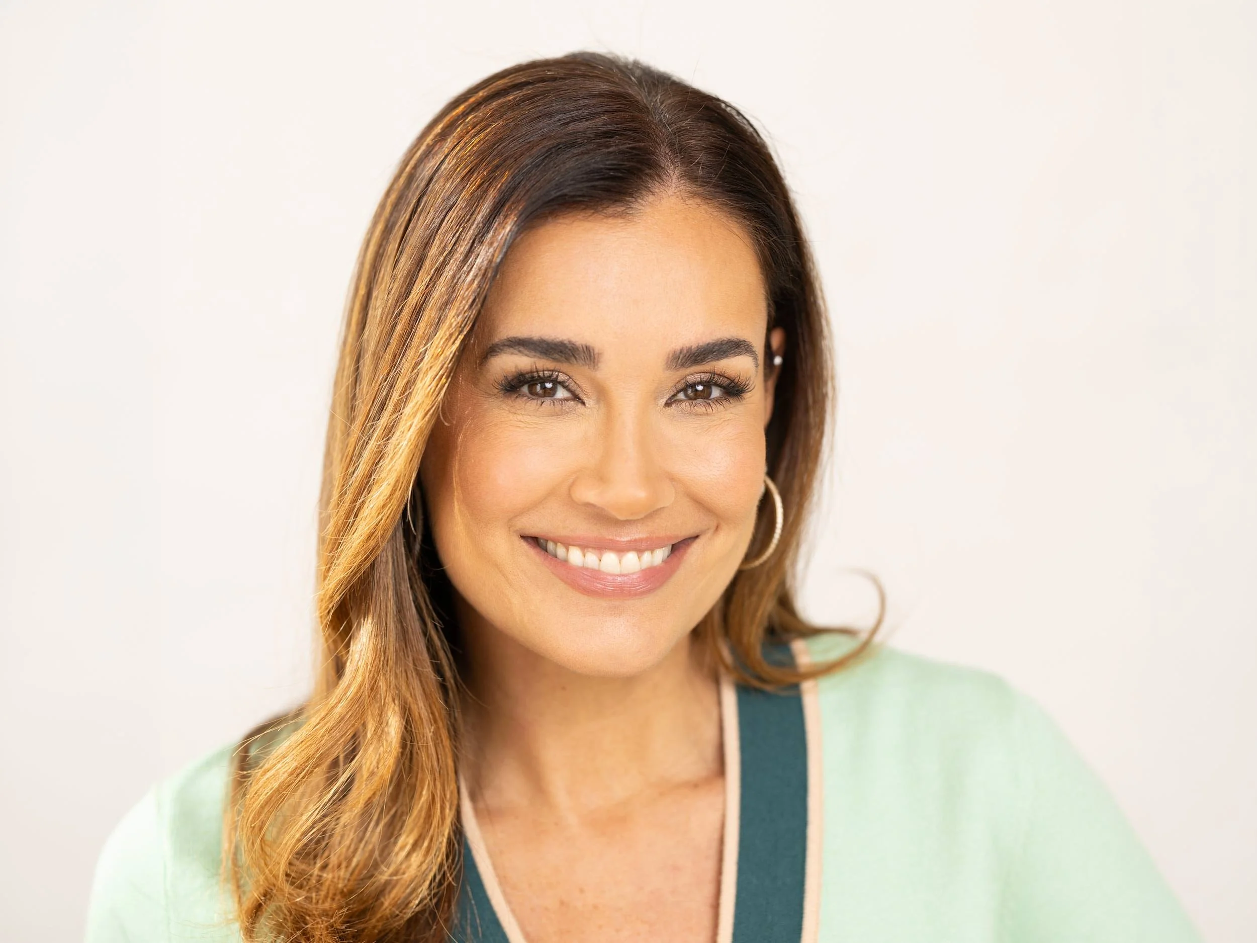 Beauty Portrait von Jana Ina mit langen braunen Haaren und grünem Oberteil