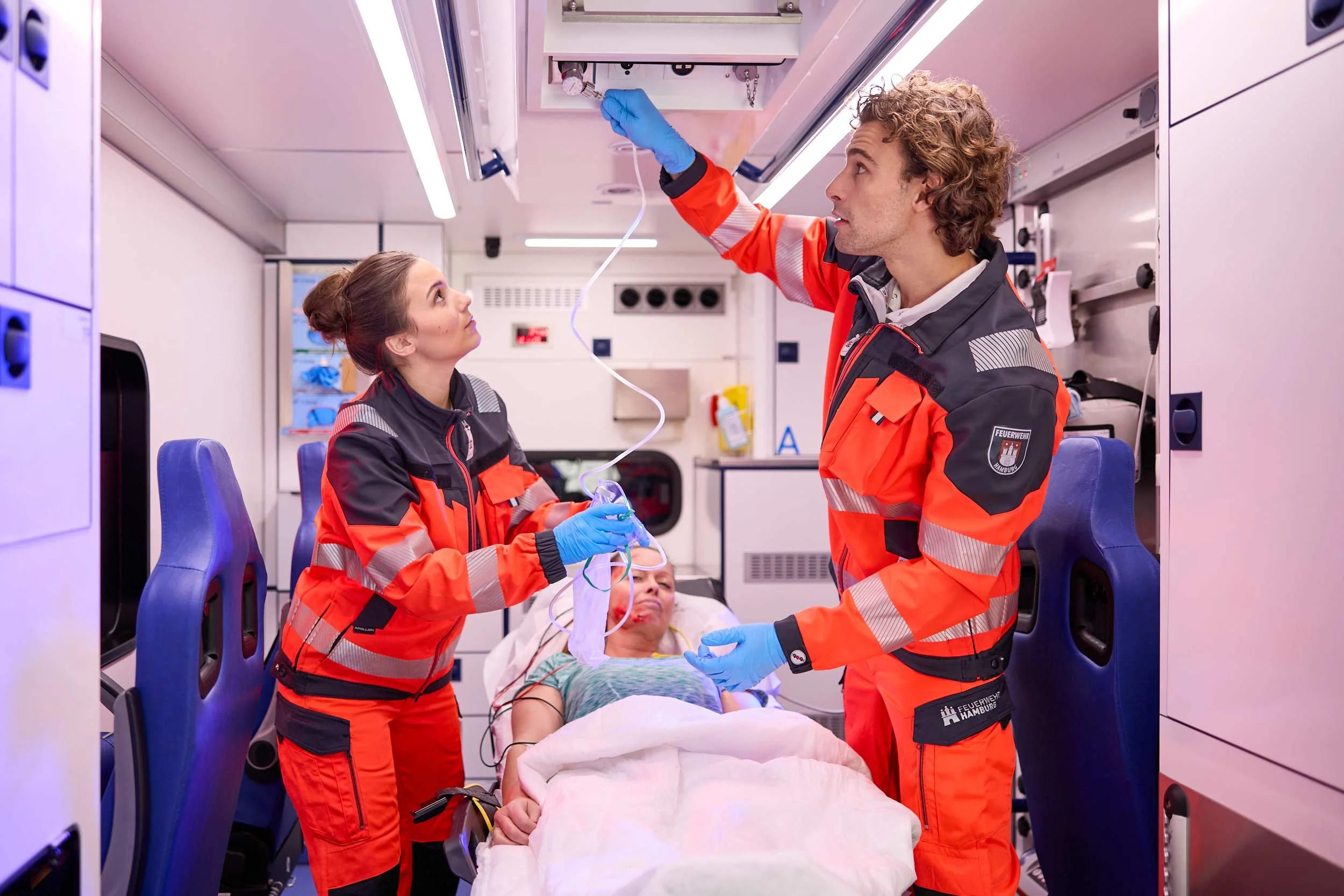 Notfallsanitäter im Rettungswagen bei der Versorgung einer Patientin