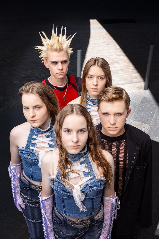 Fünf Mitglieder der Band III RIØT stehen als Gruppenporträt vor dem Futurium in Berlin und blicken in die Kamera.