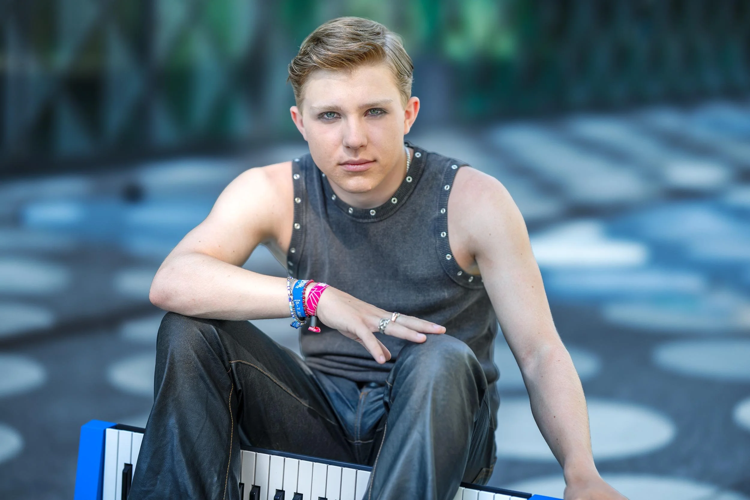 Mitglied der Band III RIØT sitzt mit einem Keyboard vor dem Futurium in Berlin und blickt in die Kamera.