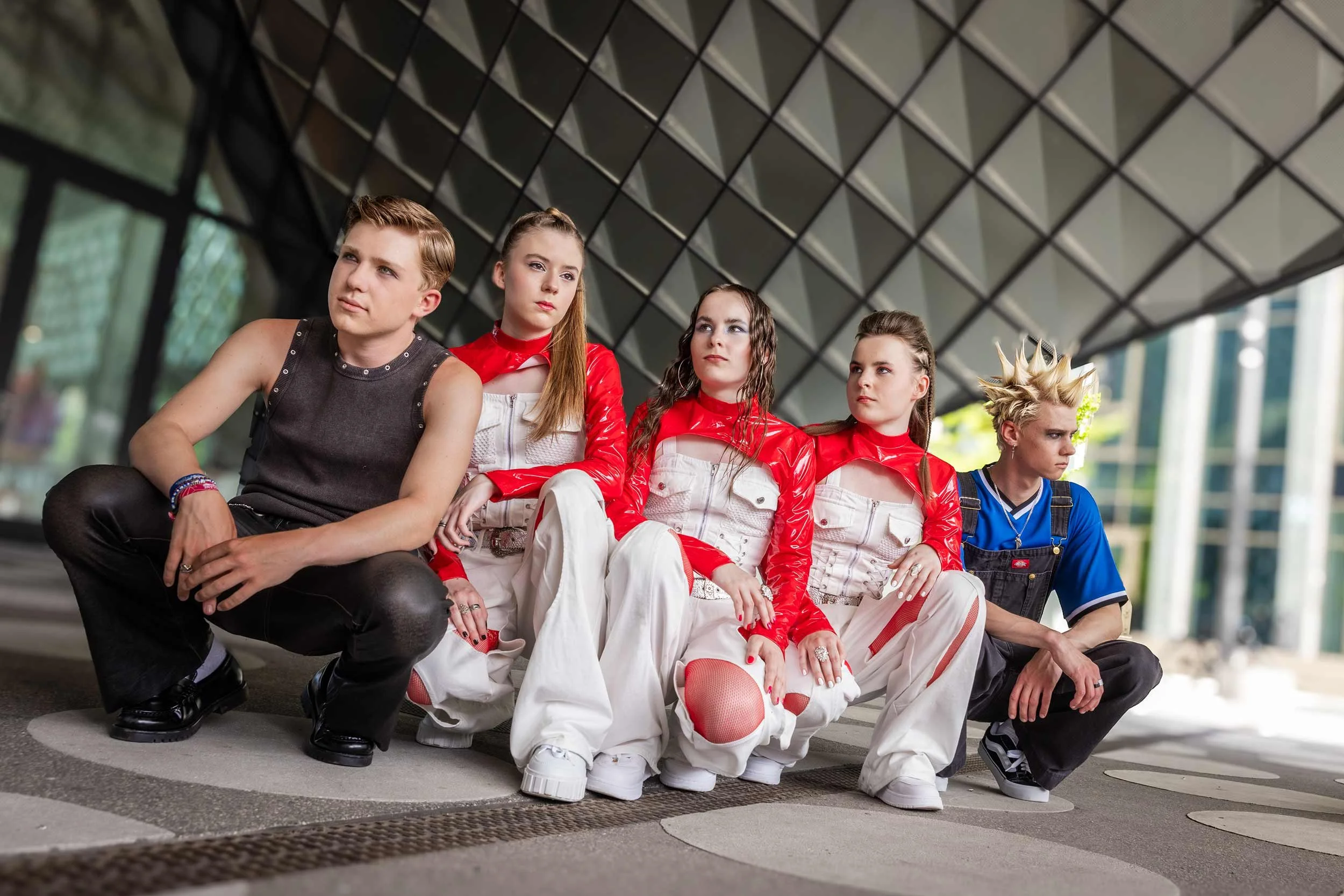 Fünf Mitglieder der Band III RIØT sitzen und knien vor der markanten Architektur des Futuriums in Berlin.