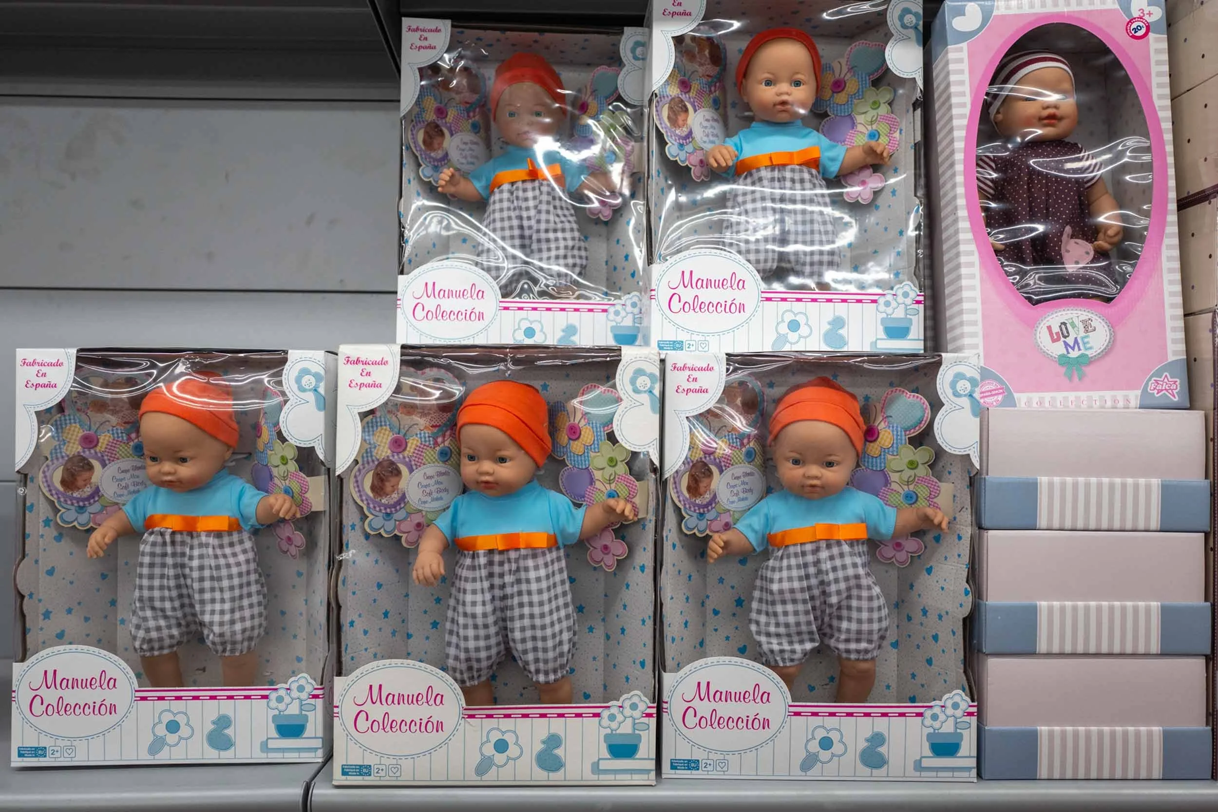 Verpackte spielzeugpuppen stehen in mehreren reihen in einem regal, gran canaria