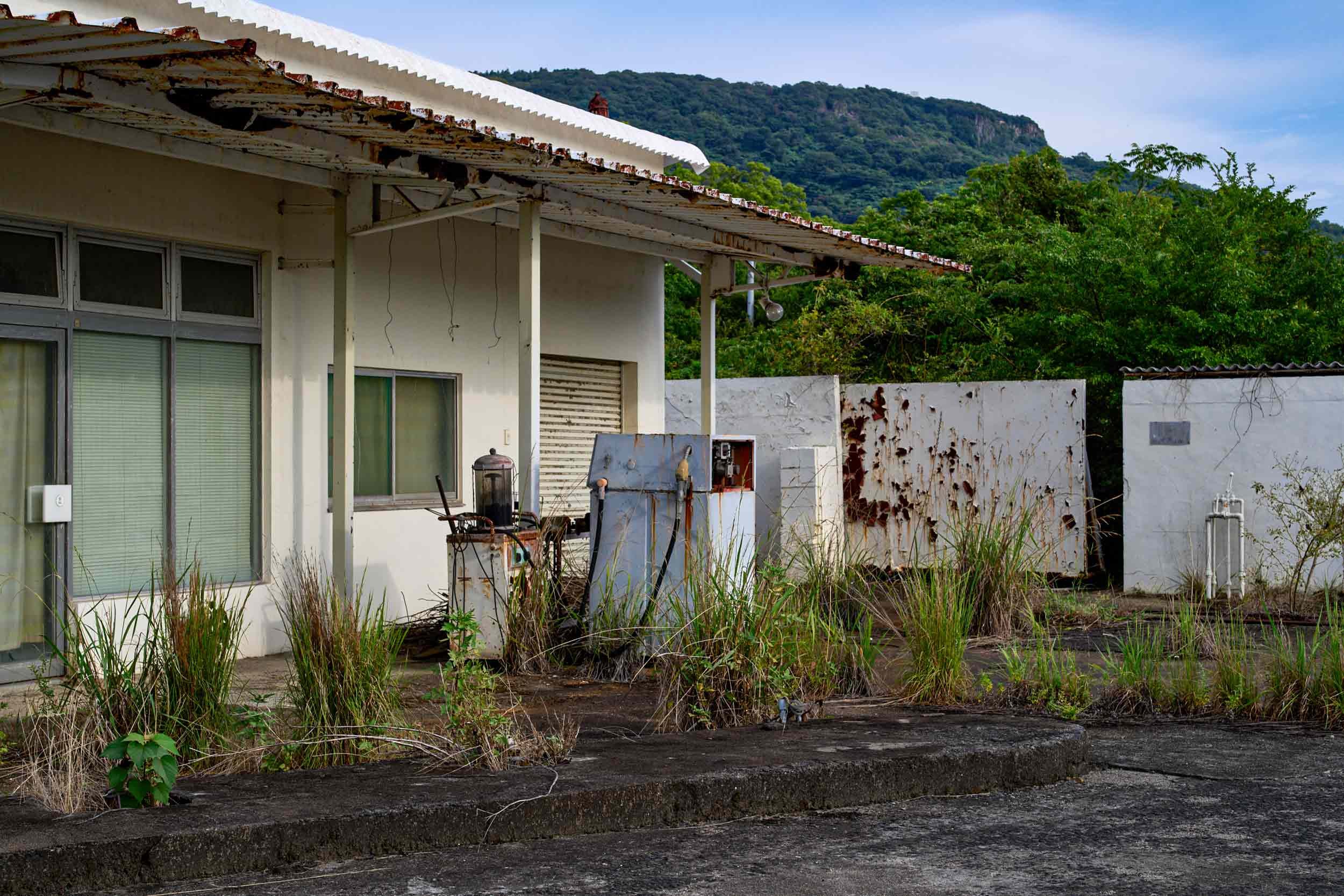 Verlassenes Gebäude mit Bewuchs, alten Geräten und rostigen Metalltafeln auf Teshima, Japan.