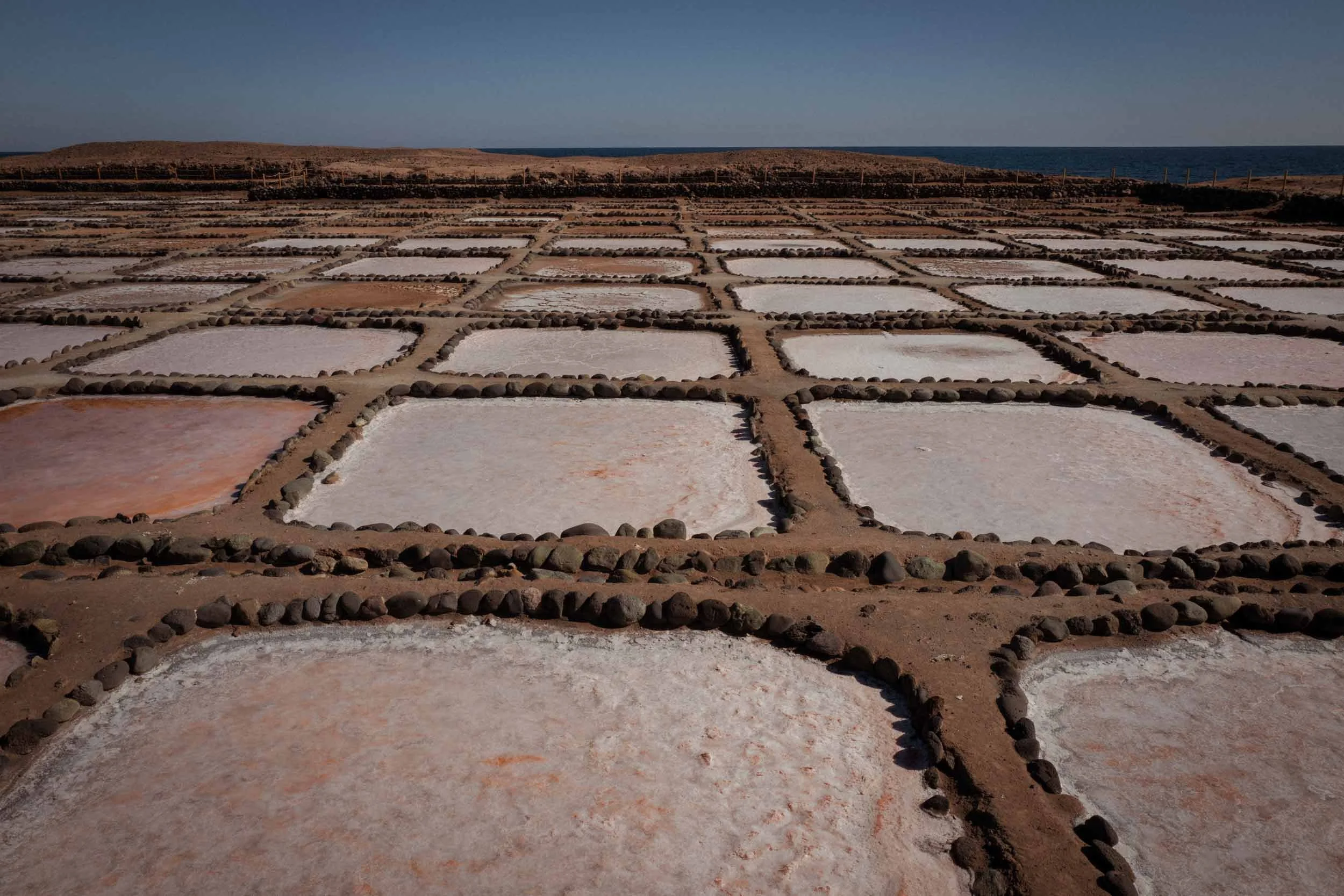 Rechteckige salzbecken mit steinraendern liegen an der kueste vor dem meer, gran canaria
