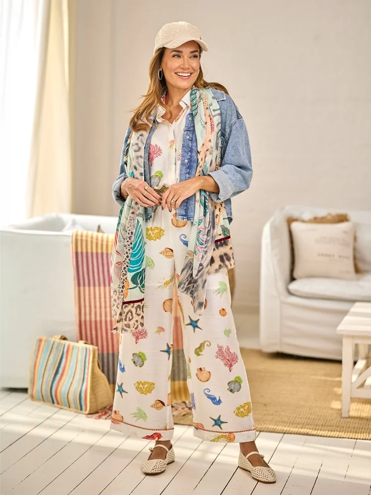Jana Ina in gemustertem Sommeroutfit mit Jeansjacke und hellem Cap im Interior