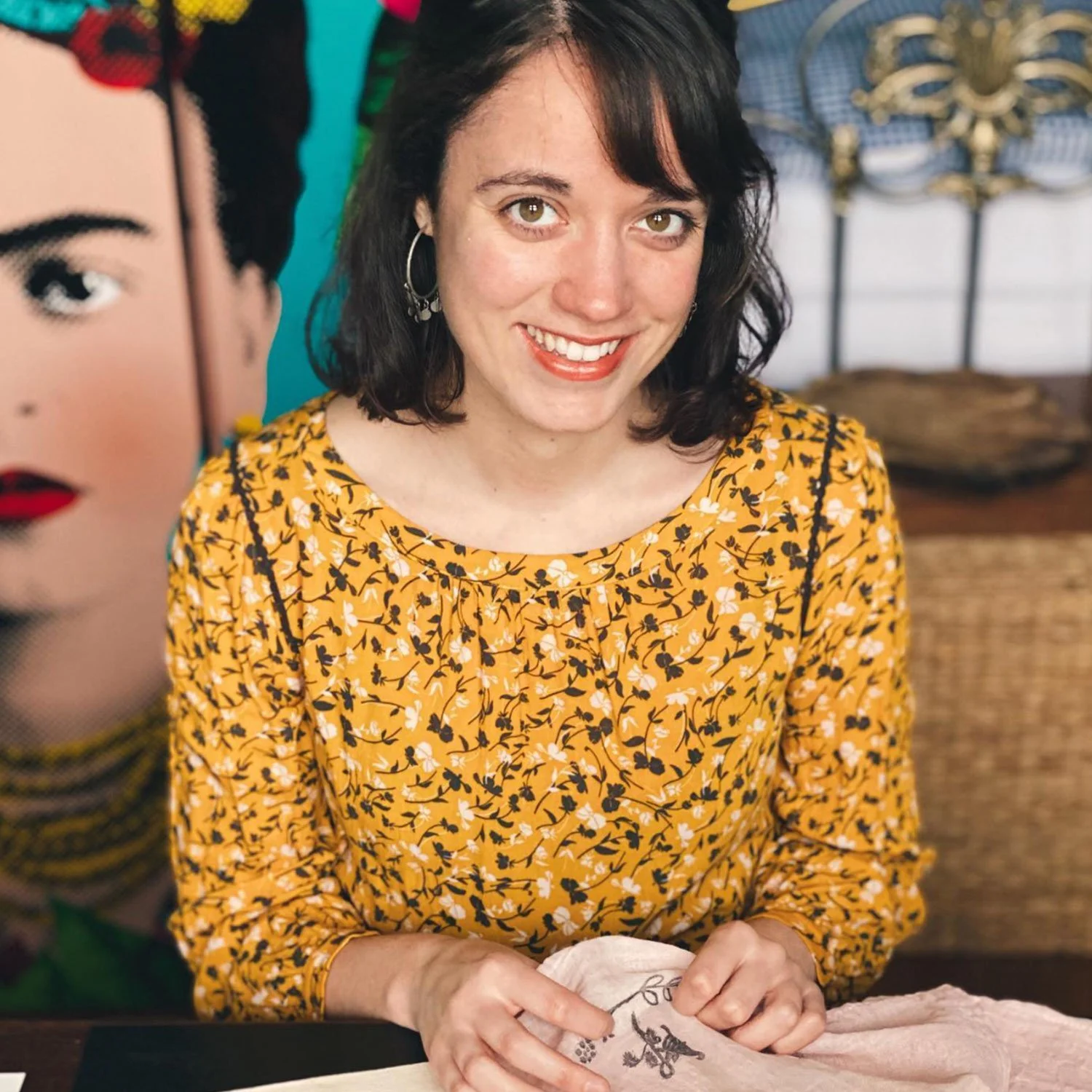 artist in yellow top looks at the camera smiling