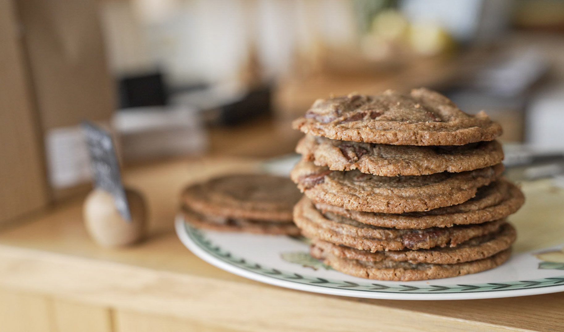 A plate of chocolate chip cookies stacked on a kitchen counter.