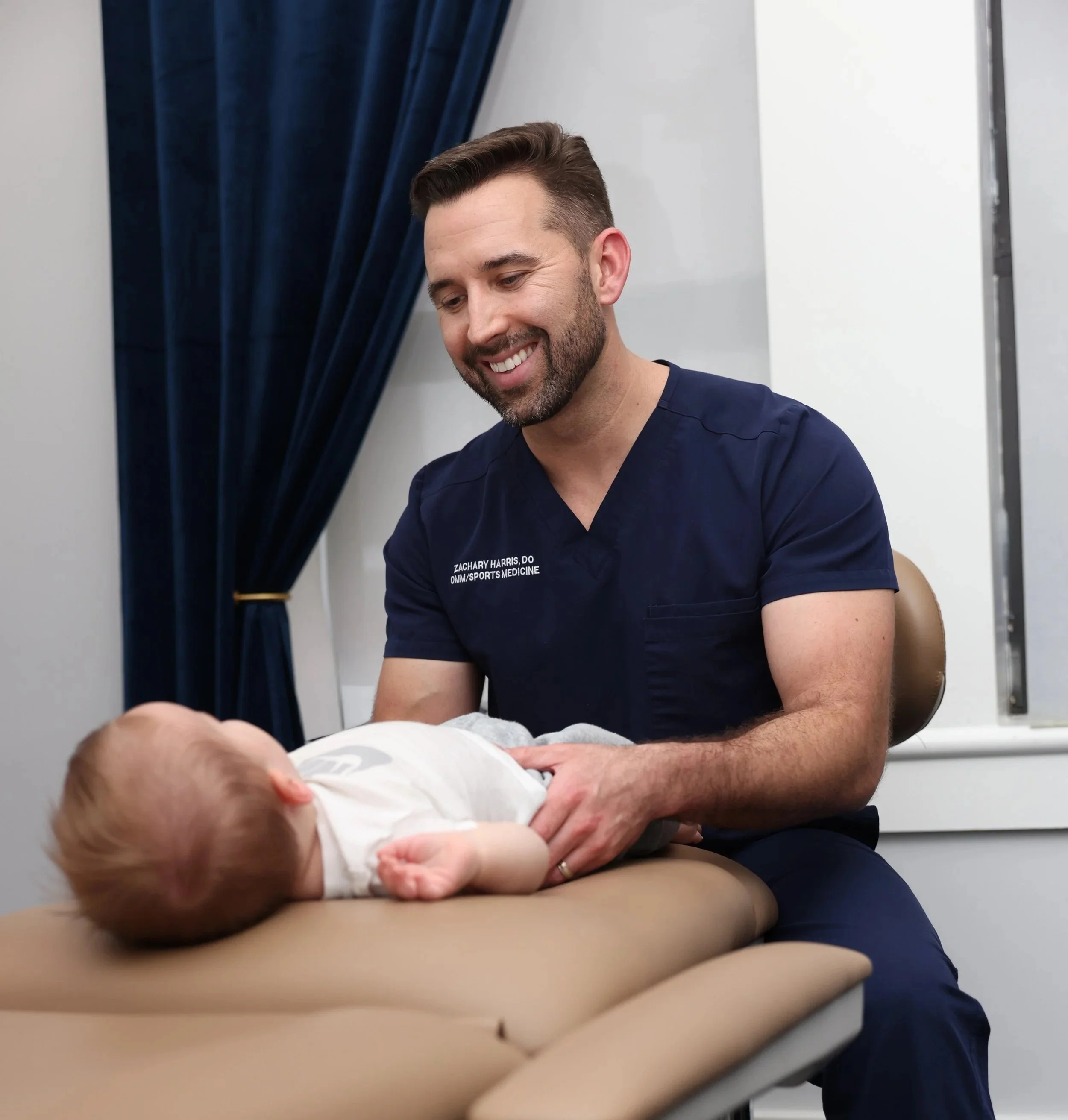Dr. Harris smiling while examining infant child
