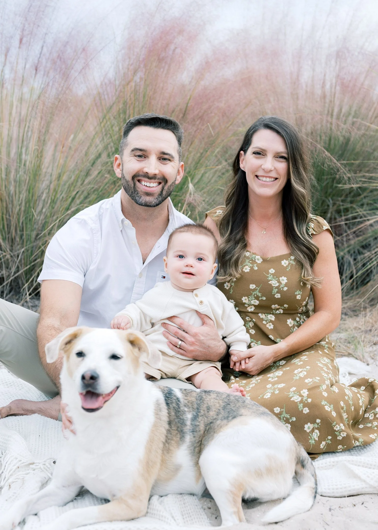 Dr. Harris posing with his wife, child, and dog on the beach