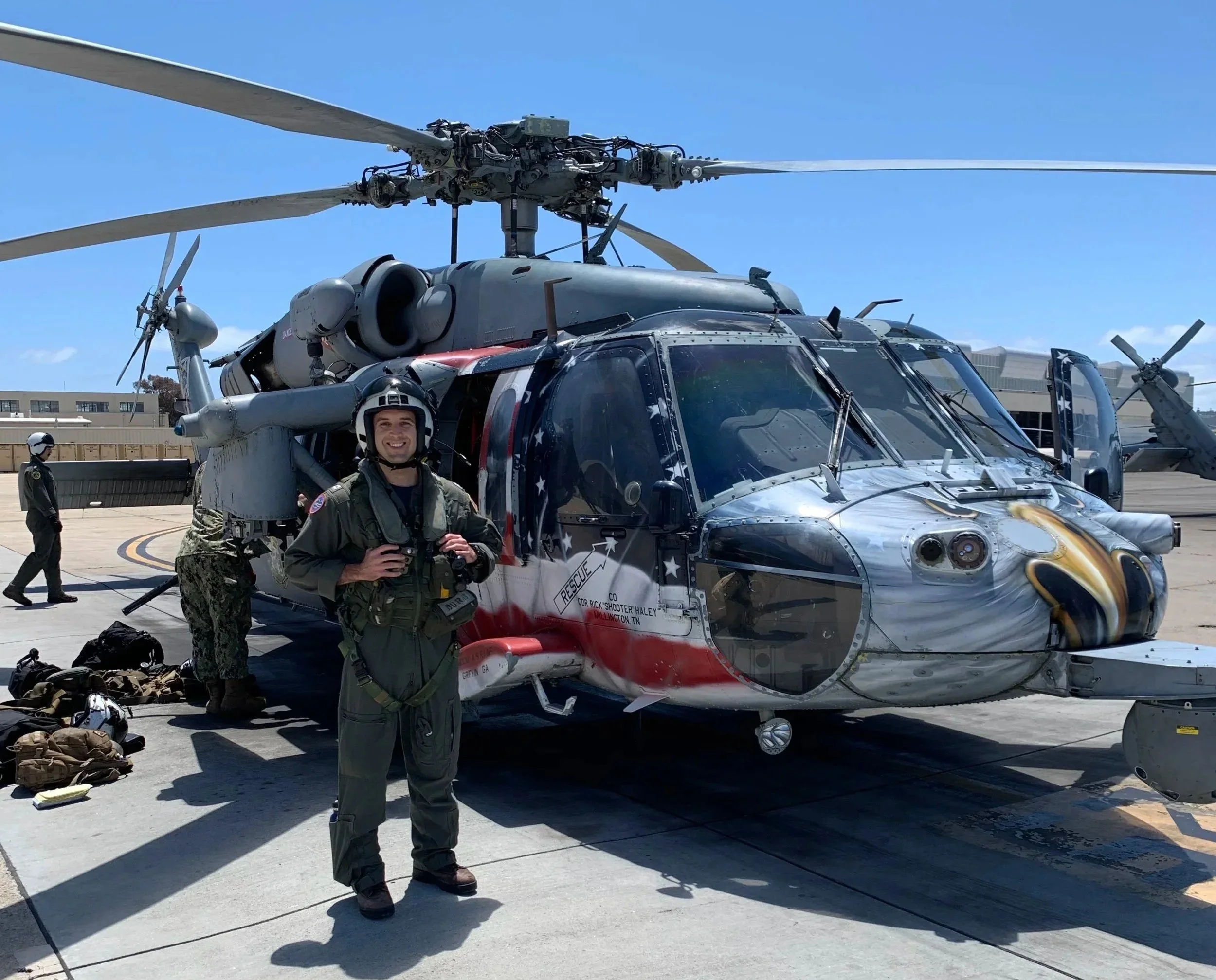 Dr. Harris in military uniform standing in front of a Blackhawk Helicopter