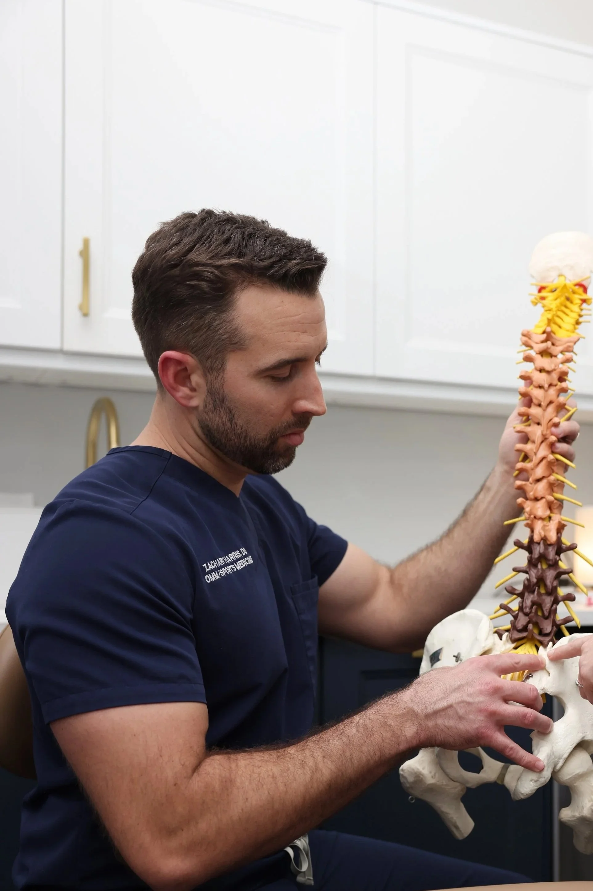Dr. Harris explaining treatment using model of a spine