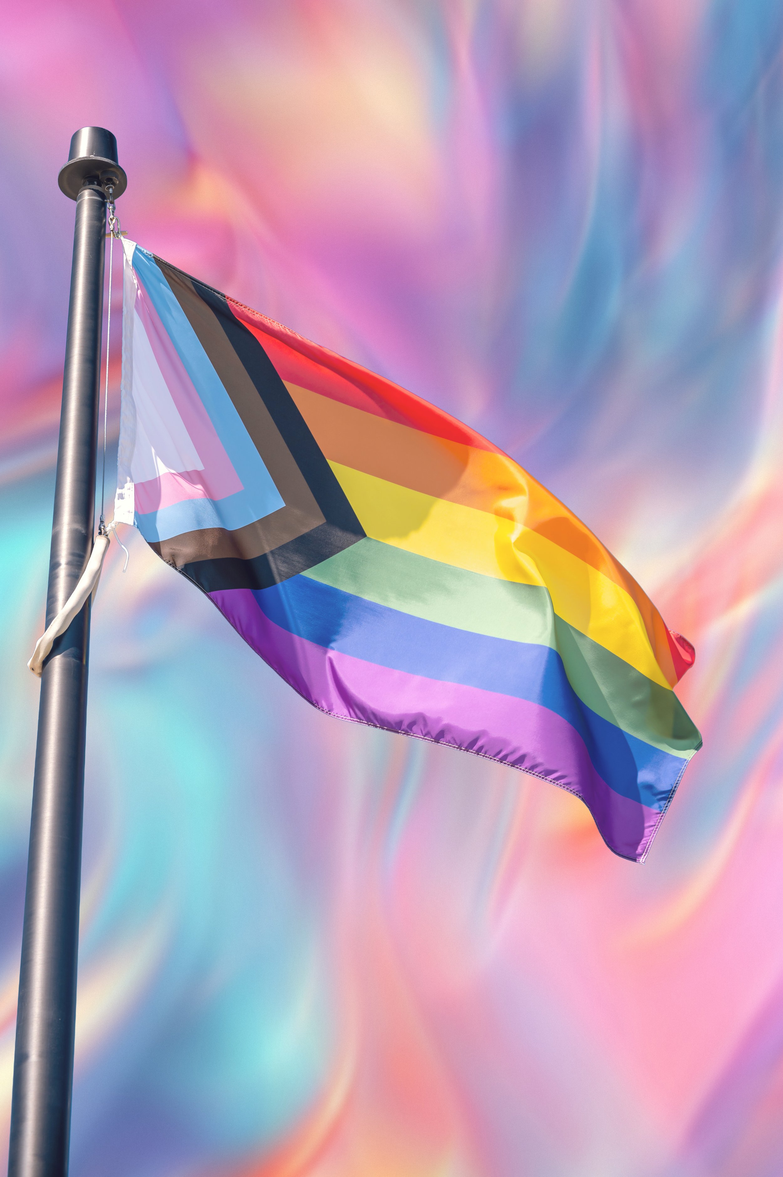 A crumpled transgender pride flag with horizontal stripes in blue, pink, white, pink, and blue.