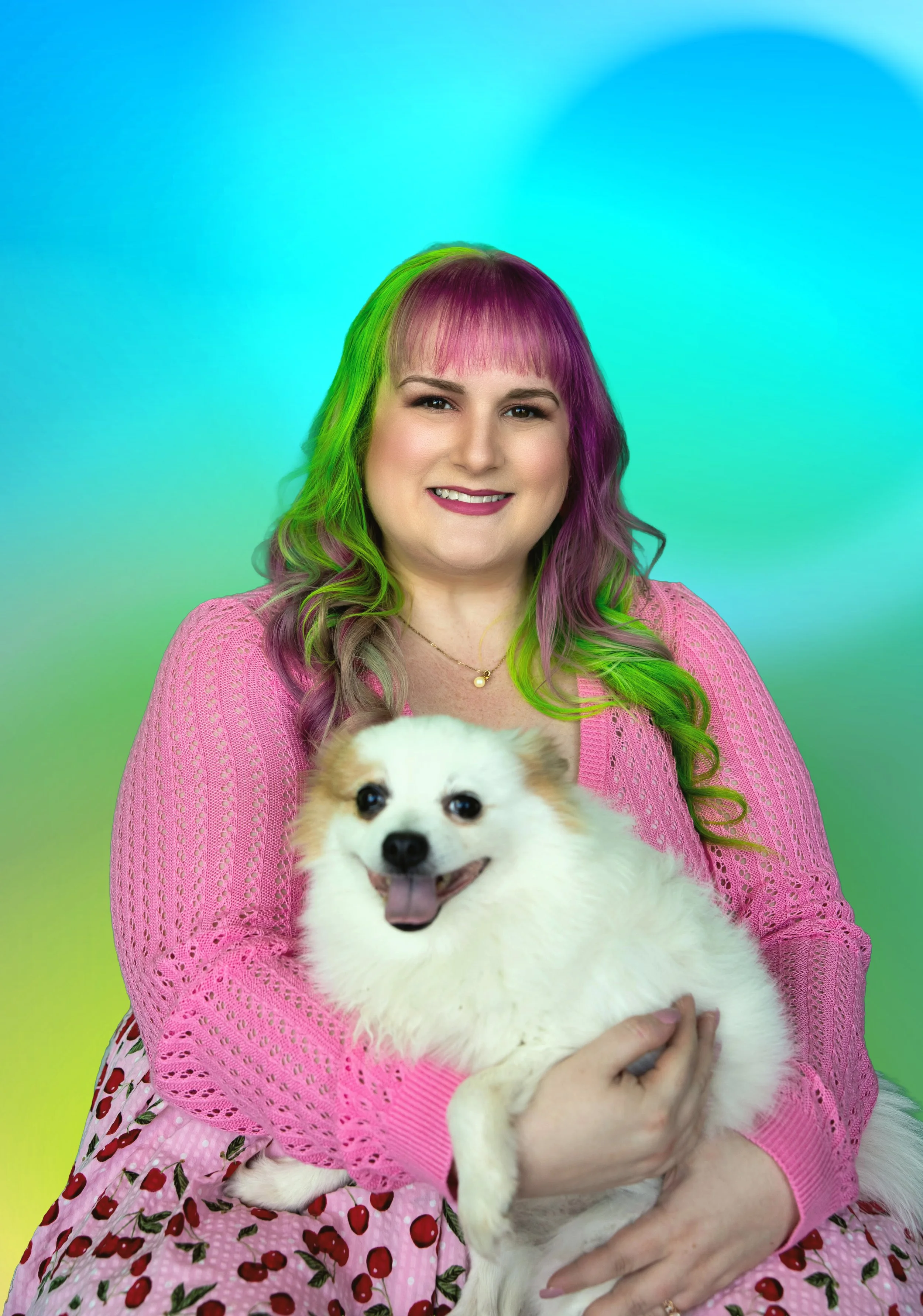 A woman with long blonde hair wearing a pink floral dress, smiling, with a colorful abstract background.