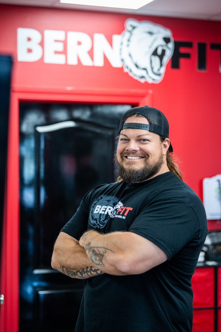 Ashley Wood, owner and head trainer at Bern Fit, standing with arms crossed in the gym