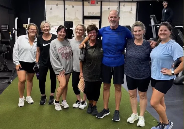 Class members standing in a line on the turf after a group workout at Bern Fit
