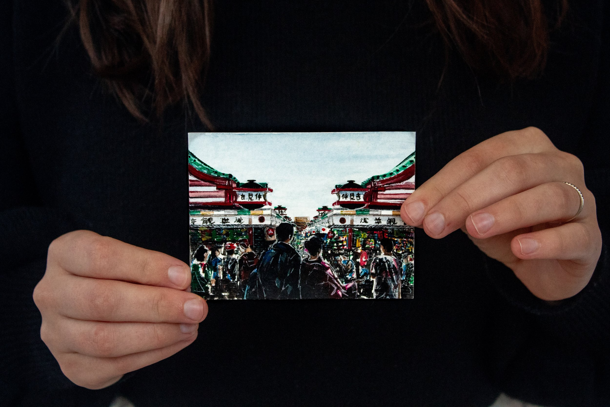 Artist Emma Carr holding the original watercolor painting "Kaimono"