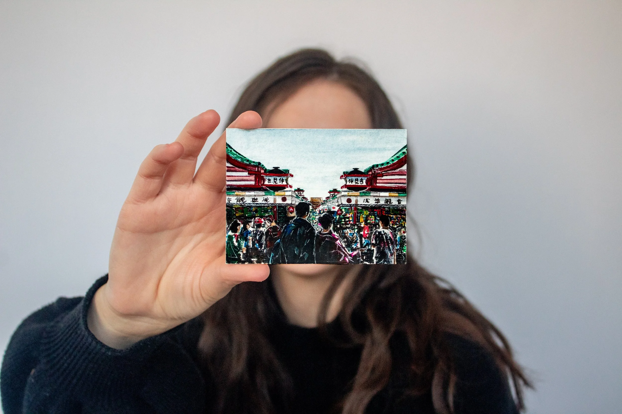 Artist Emma Carr holding the original watercolor painting "Kaimono"