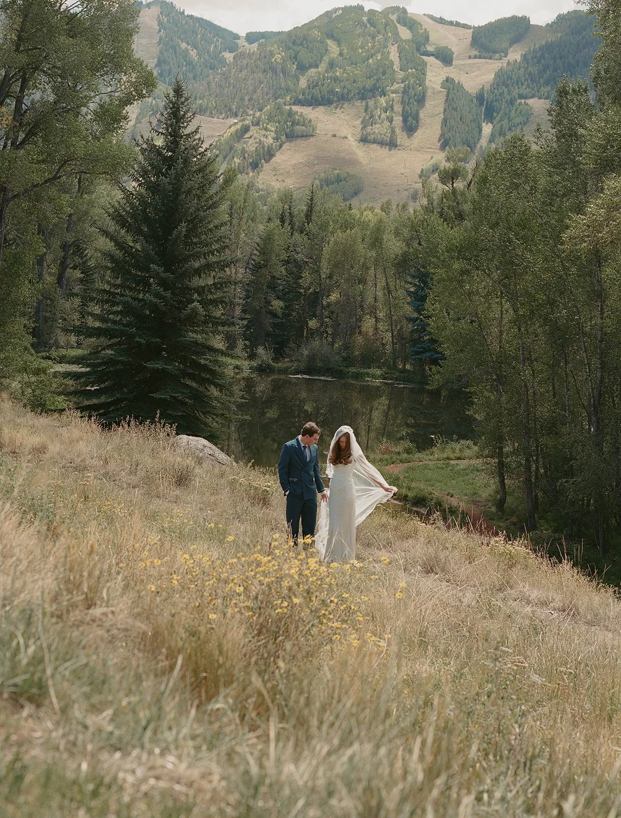 couple having a candid moment adjusting a veil overlooking a private view of Aspen