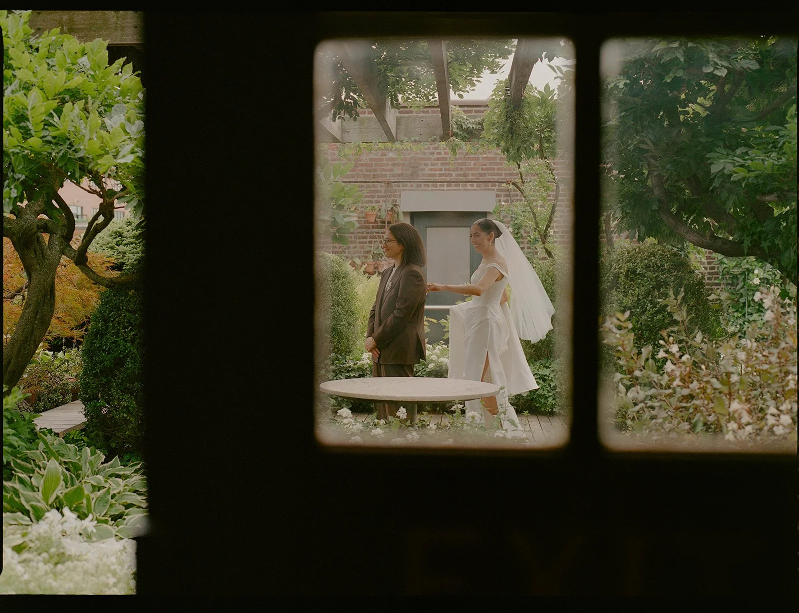 a cinematic first look framed by doors and greenery