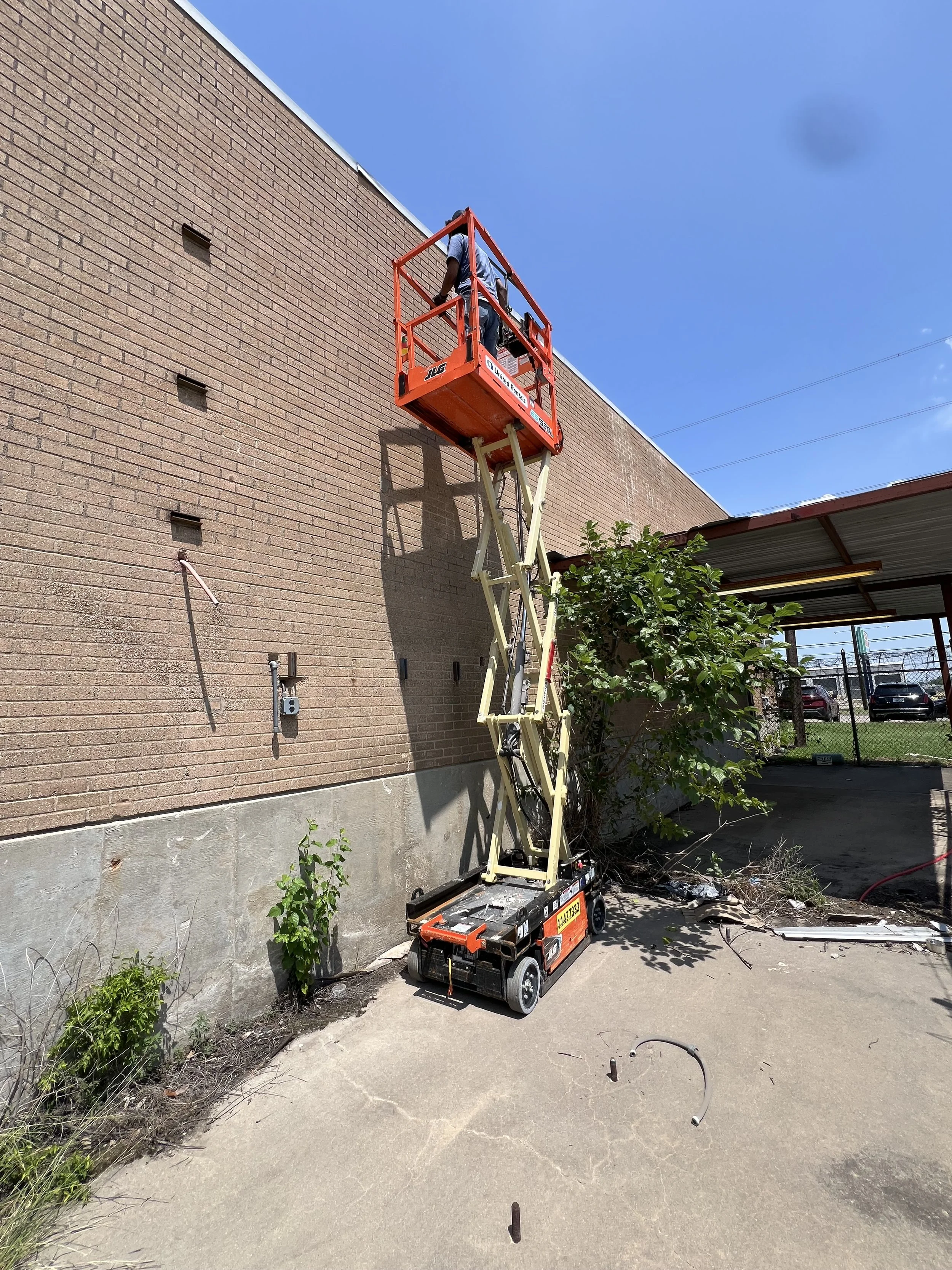 A scissor lift outside of a warehouse