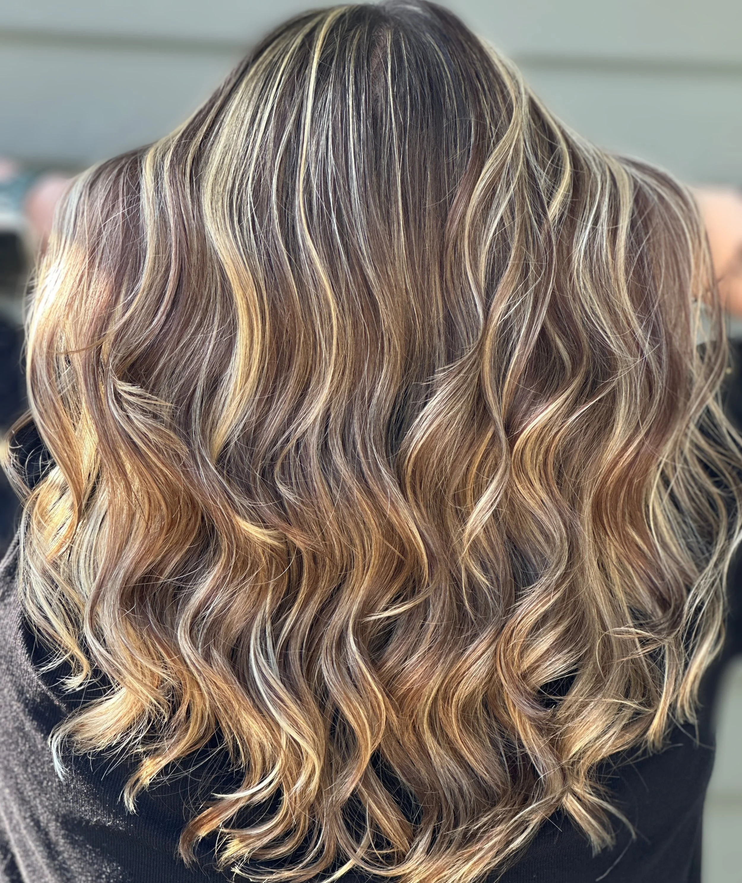 Back view of wavy, highlighted hair in shades of blonde and brown.