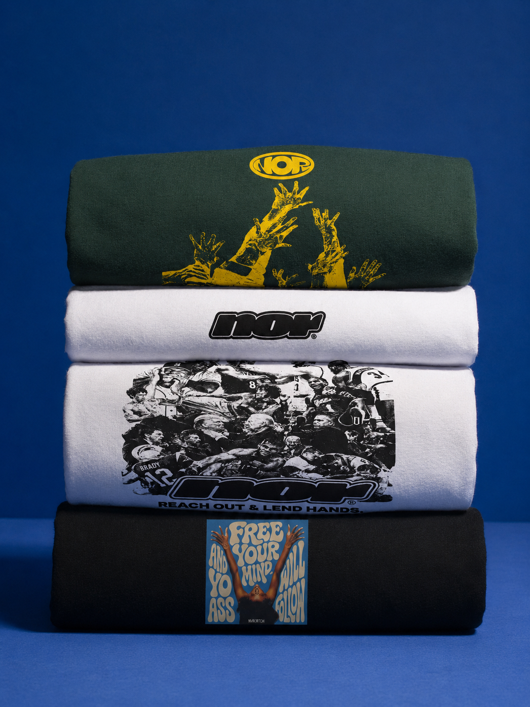 Four folded t-shirts stacked on top of each other against a blue background, each with different graphic designs and text.