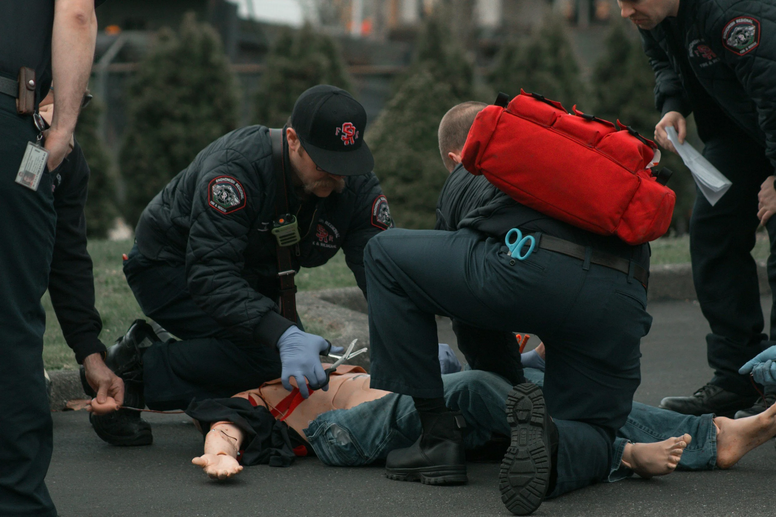 First responders providing emergency care at a crisis scene, representing vicarious trauma, stress, and the hidden emotional weight of emergency work.